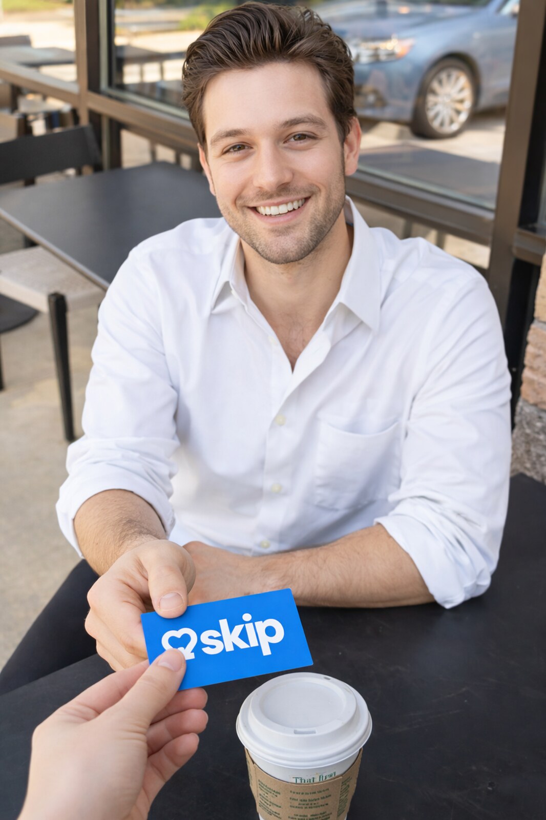 A man receives a blue Skip physical Date Card at a café