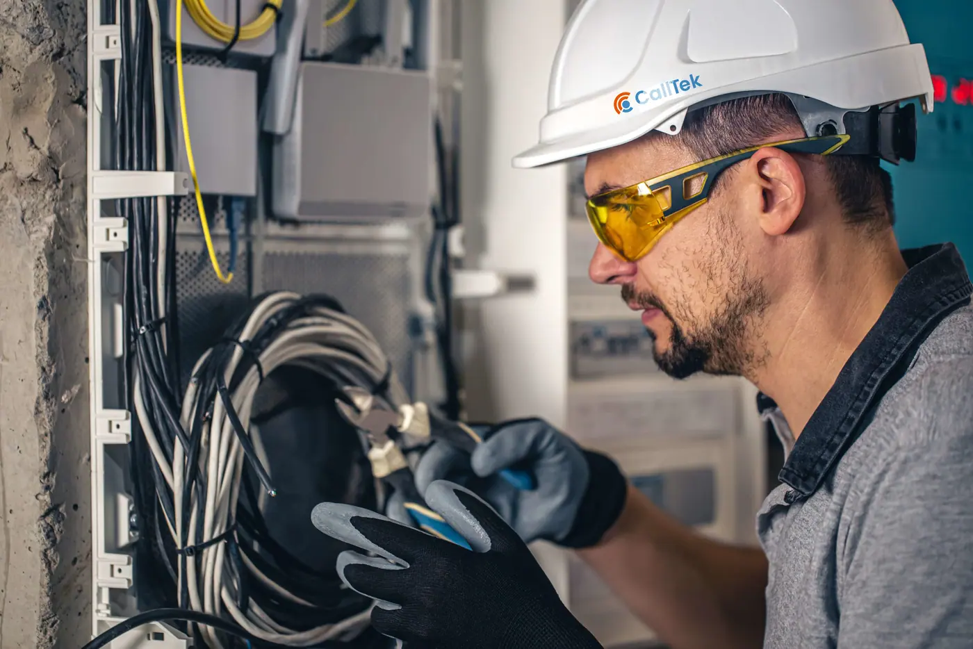 Field service technician in a hard hat working on site cabling