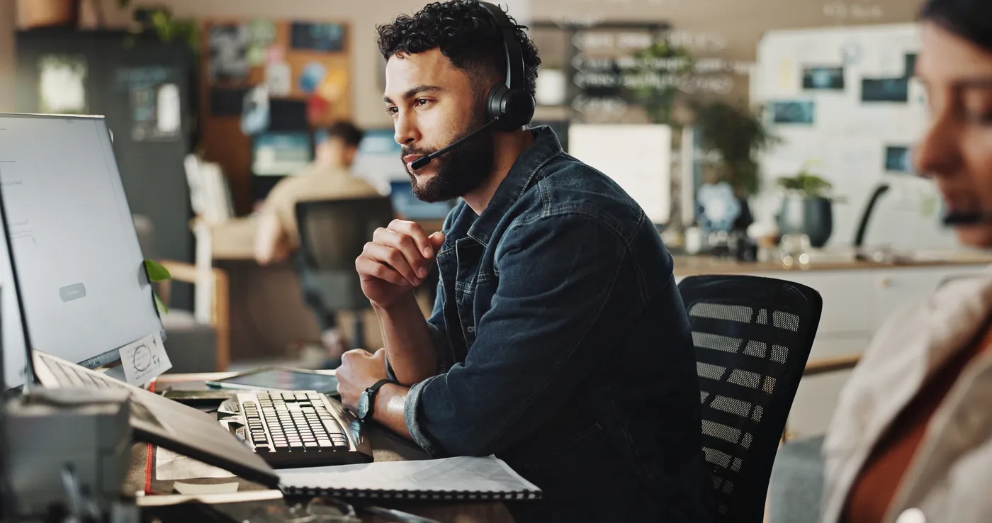 Tech support engineer working a ticket across multiple monitors