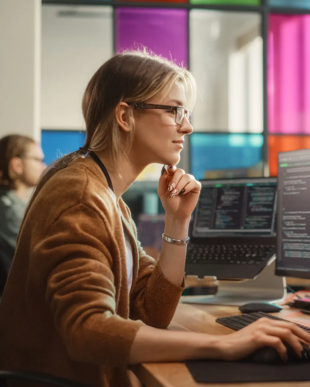 SaaS team member working at a multi-monitor workstation