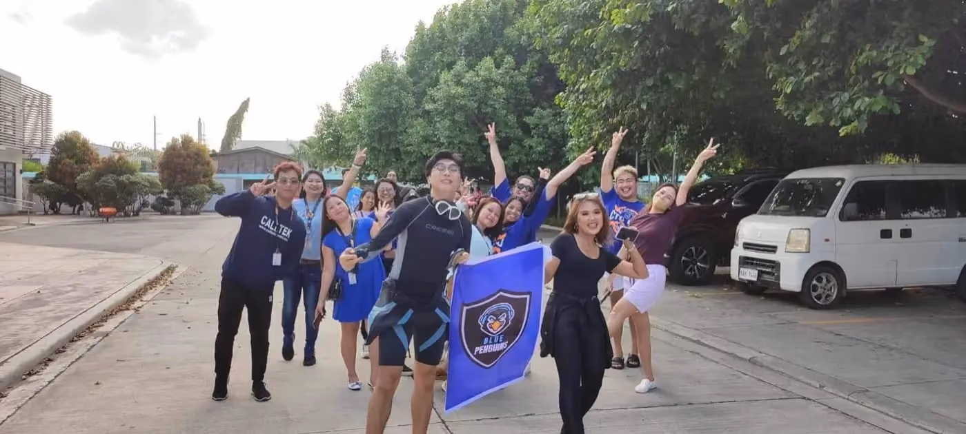 The Blue Penguins team cheering with their flag before a company event
