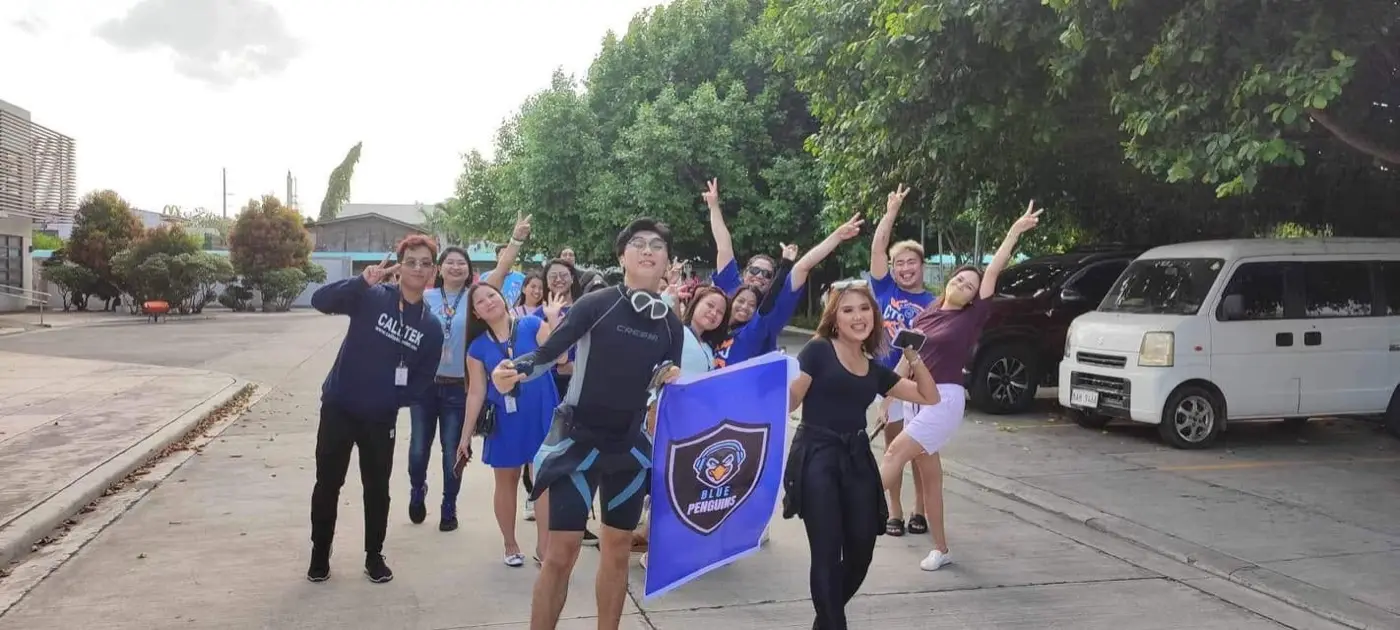 The Blue Penguins team cheering with their flag before a company event