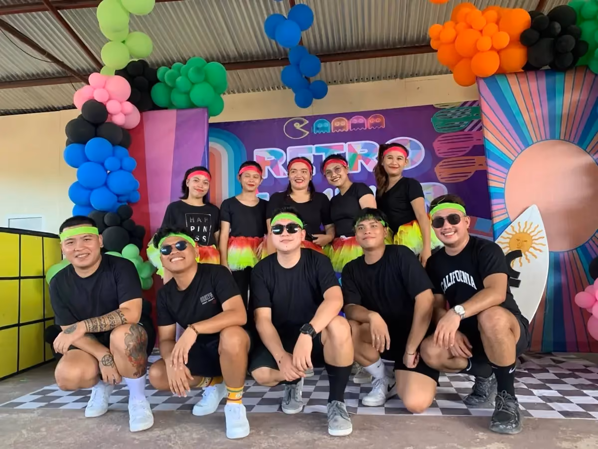 A team in matching retro outfits at a company event