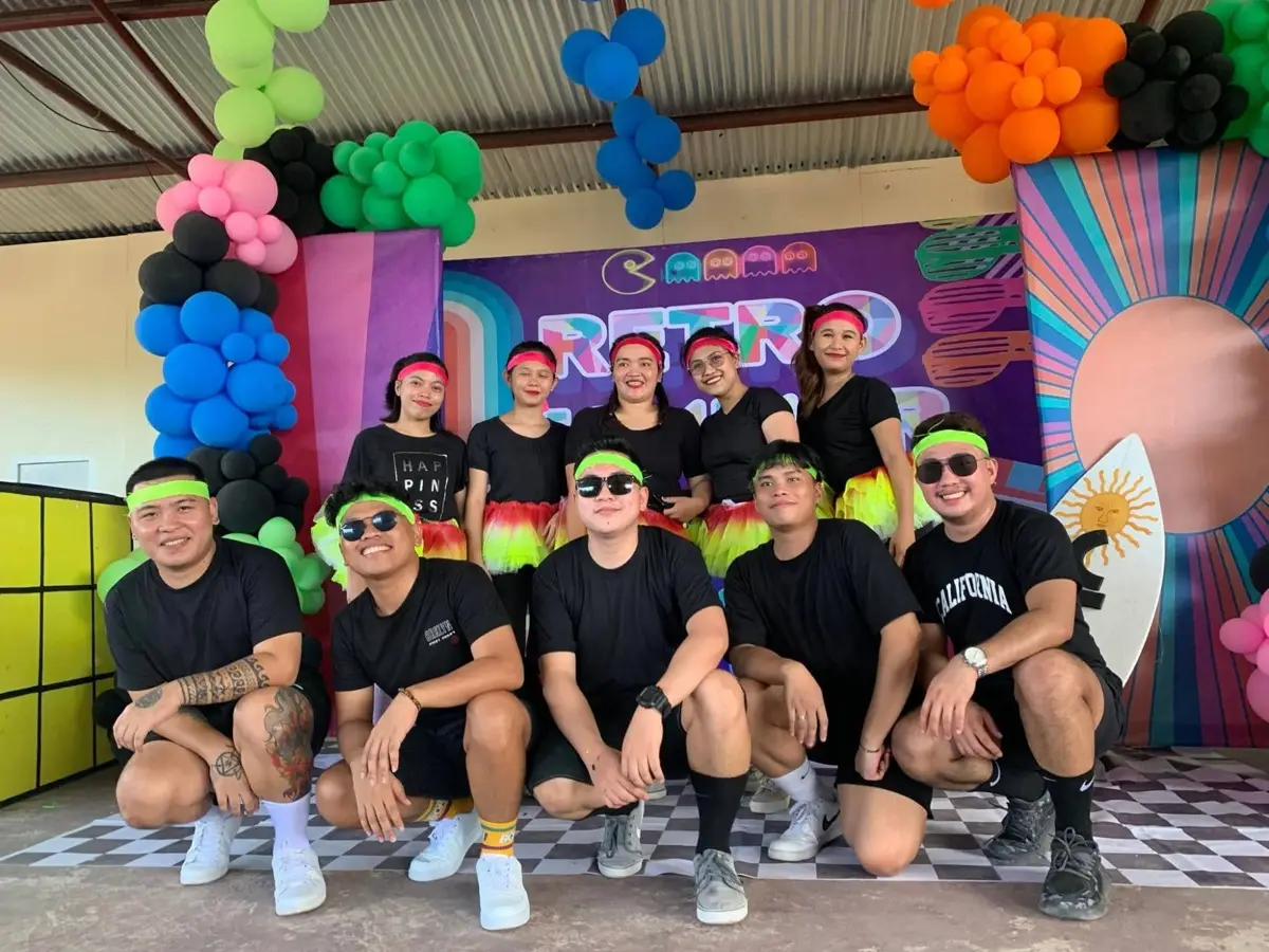 A team in matching retro outfits at a company event