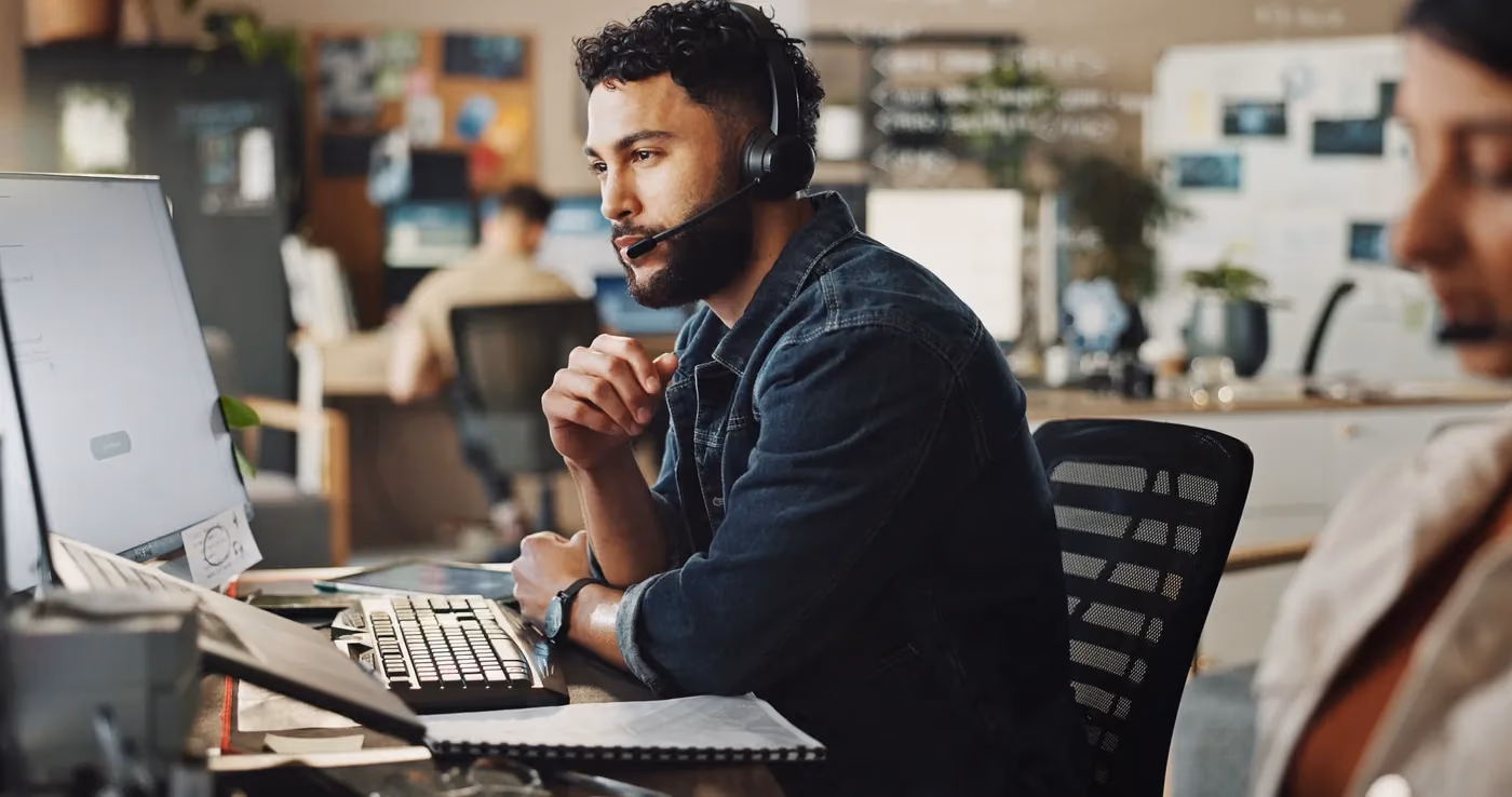 Tech support engineer working a ticket across multiple monitors