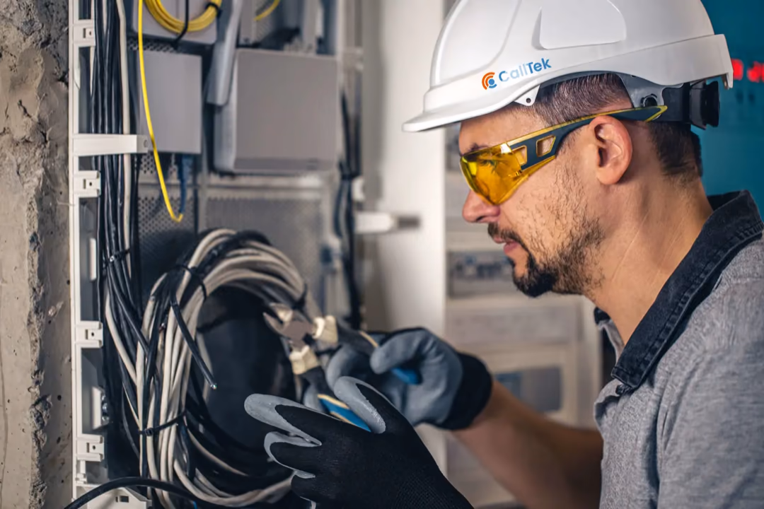 Field service technician in a hard hat working on site cabling