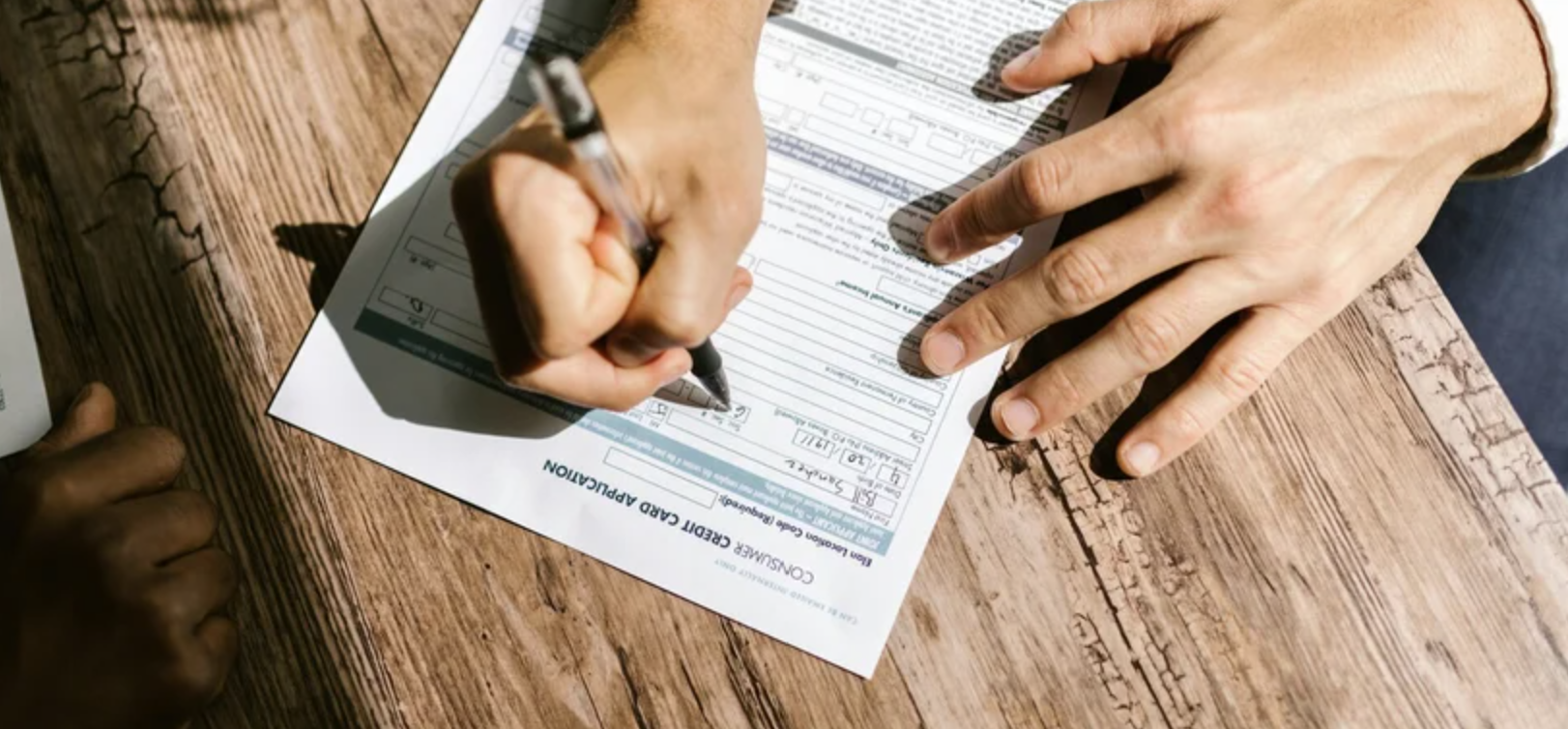 A hand filling out a volunteer sign-up form