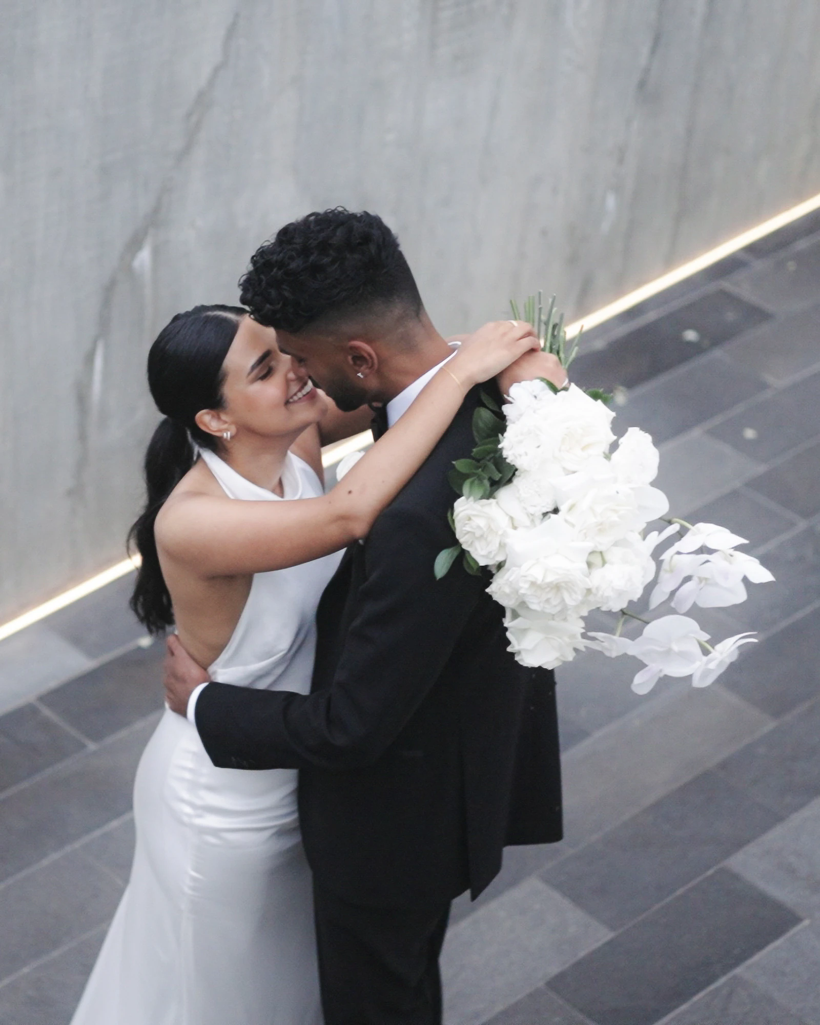 Overhead view of a couple embracing beside a stone wall