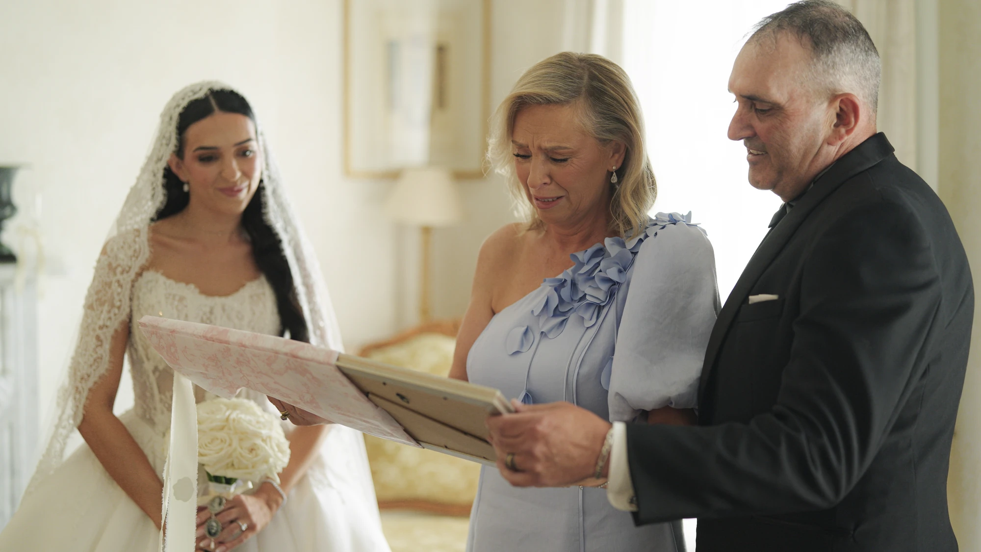 Bride and two people looking at a keepsake together