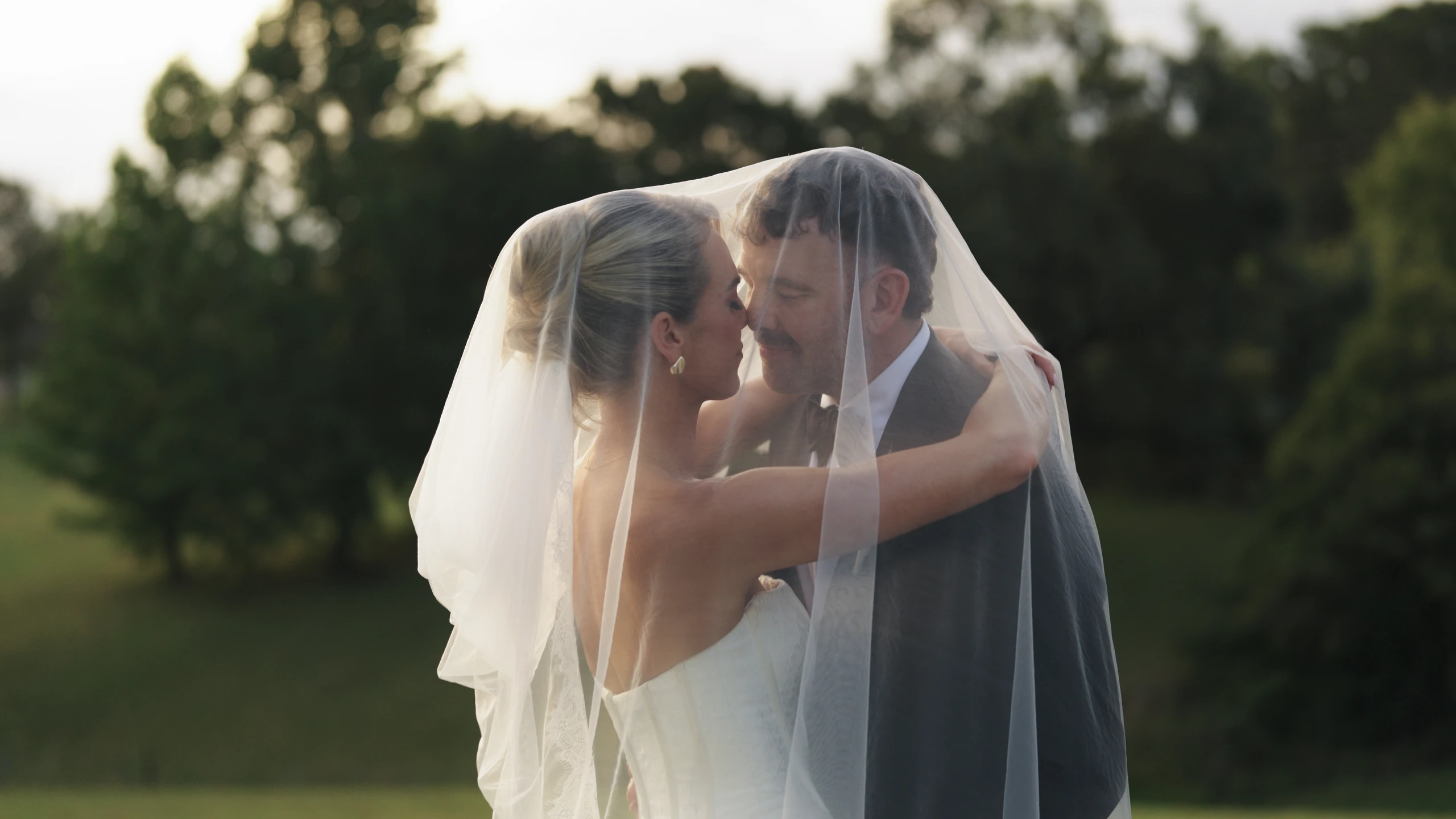Couple embracing beneath a veil