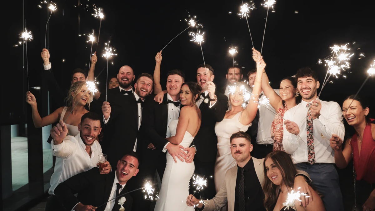 Newlyweds and guests celebrating with sparklers