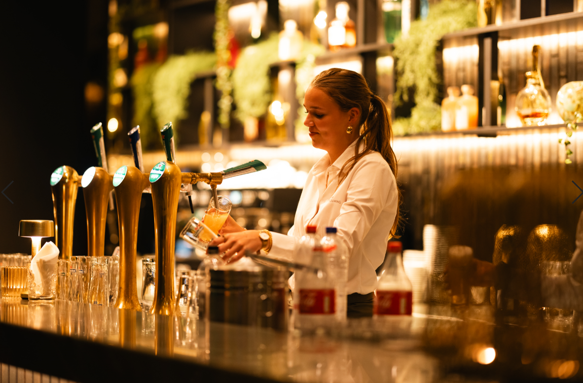 Medewerkster maakt een drankje achter de bar