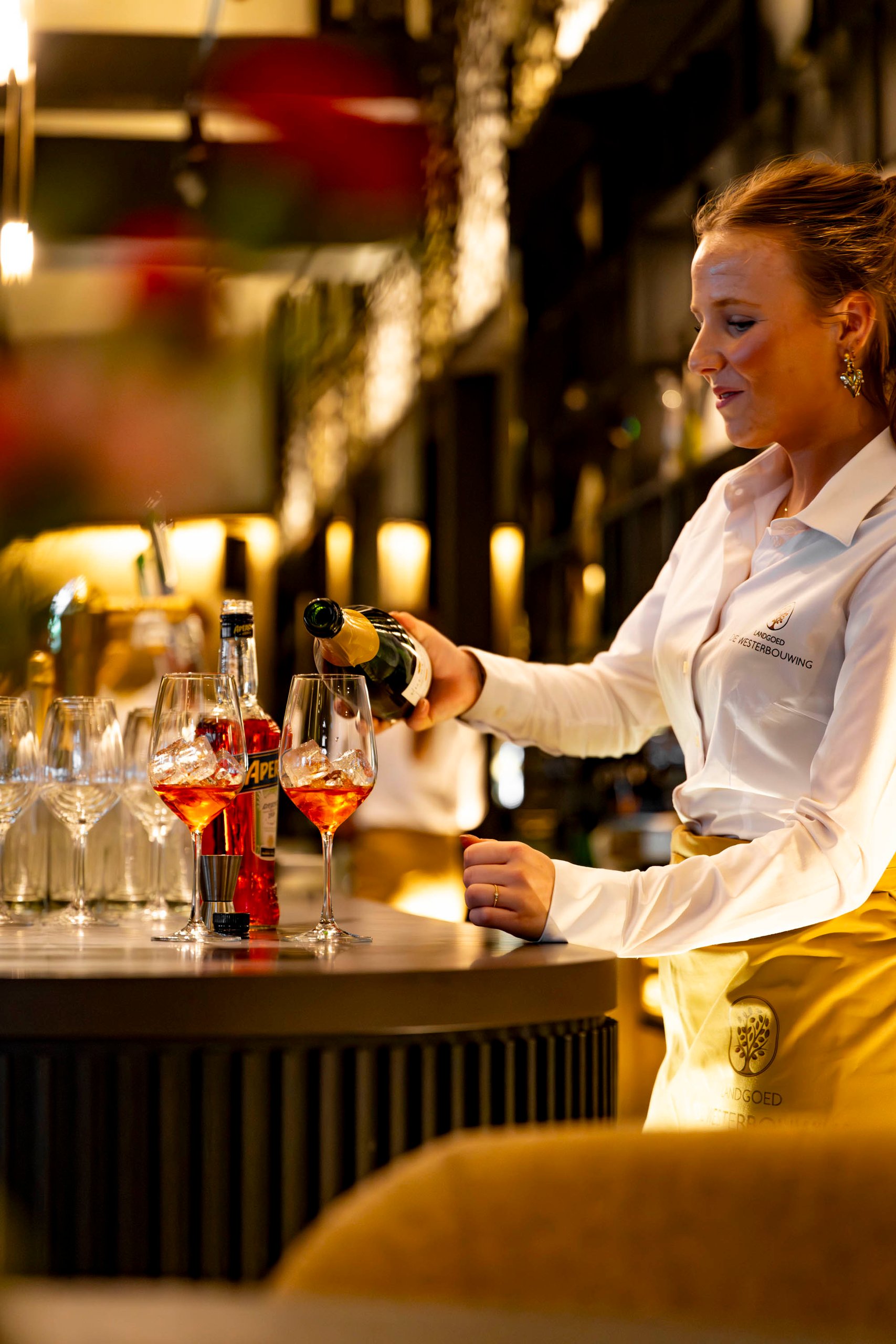 Bediening schenkt de aperitieven in