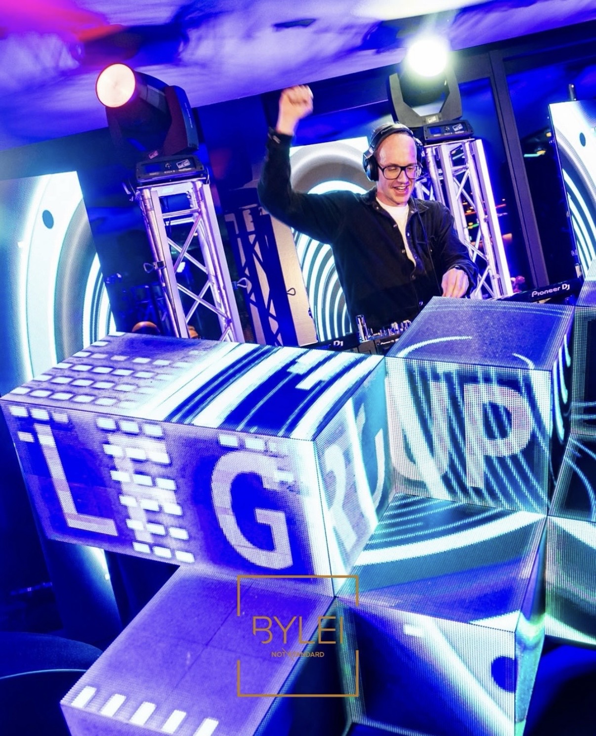 DJ achter verlichte kubussen met het logo van LF Group