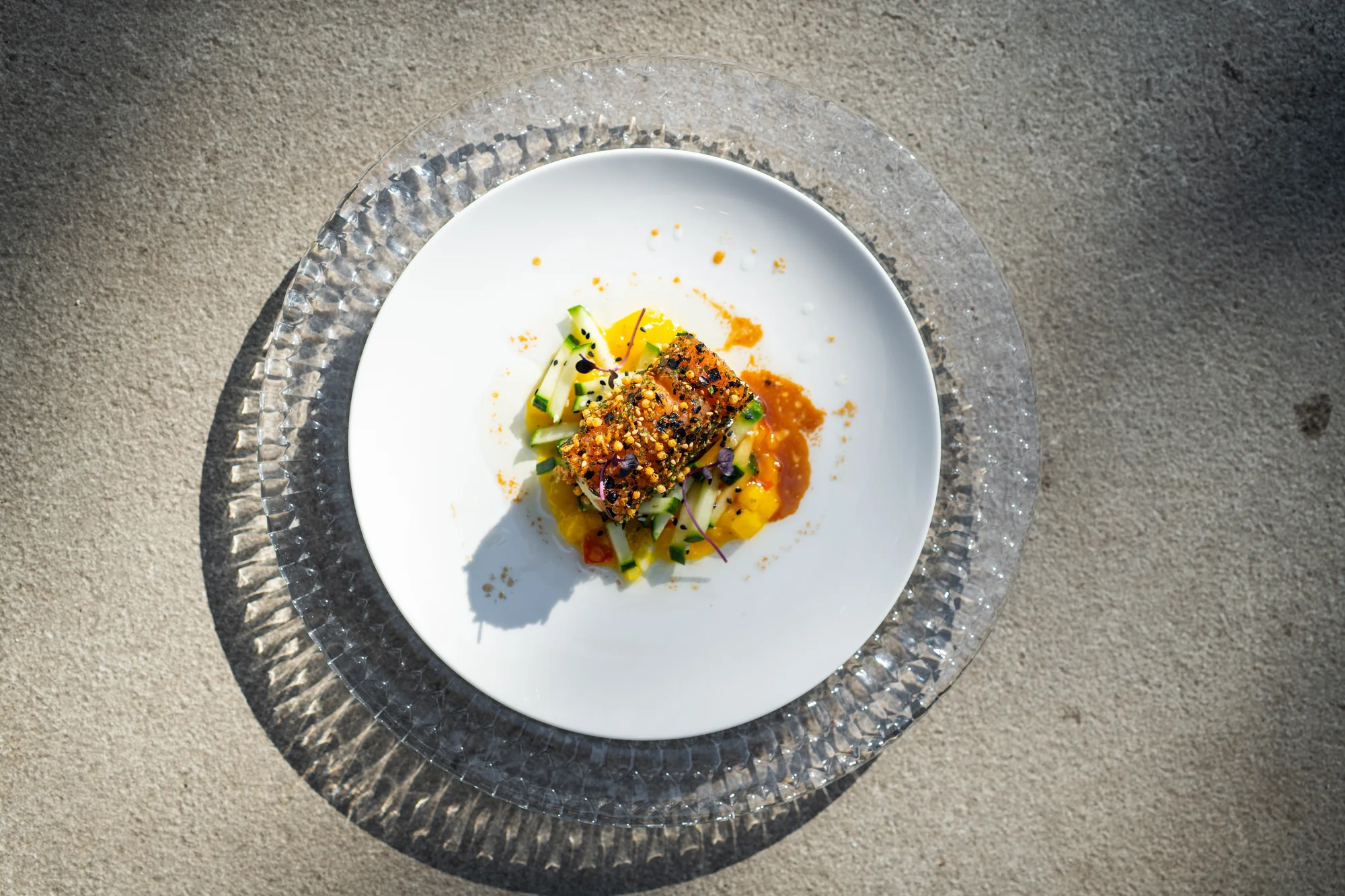 Rouleau van gerookte zalm met avocadocrème en furikake, van bovenaf op een wit bord