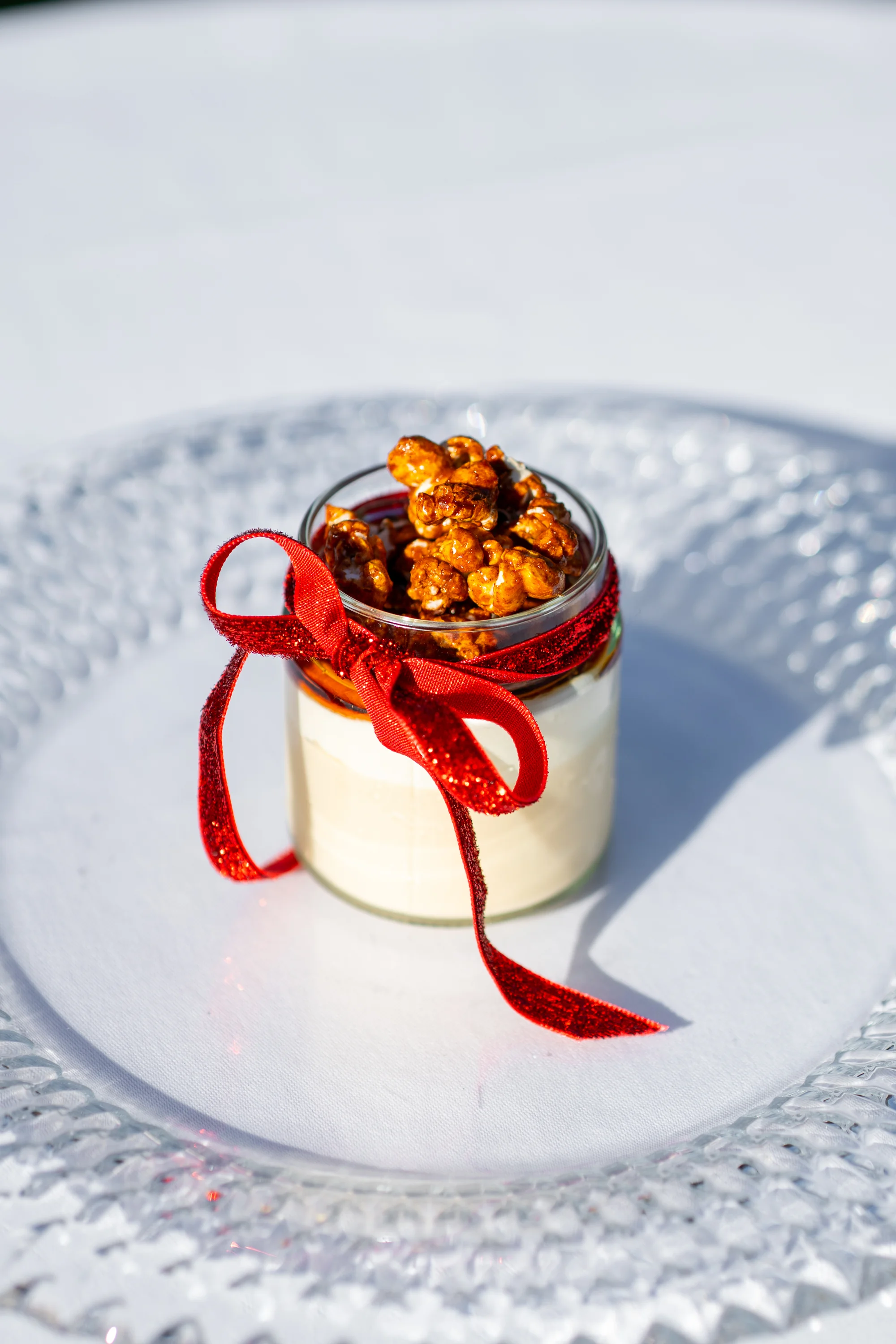 Mousse van Baileys met karamelpopcorn in een glaasje met rood lint