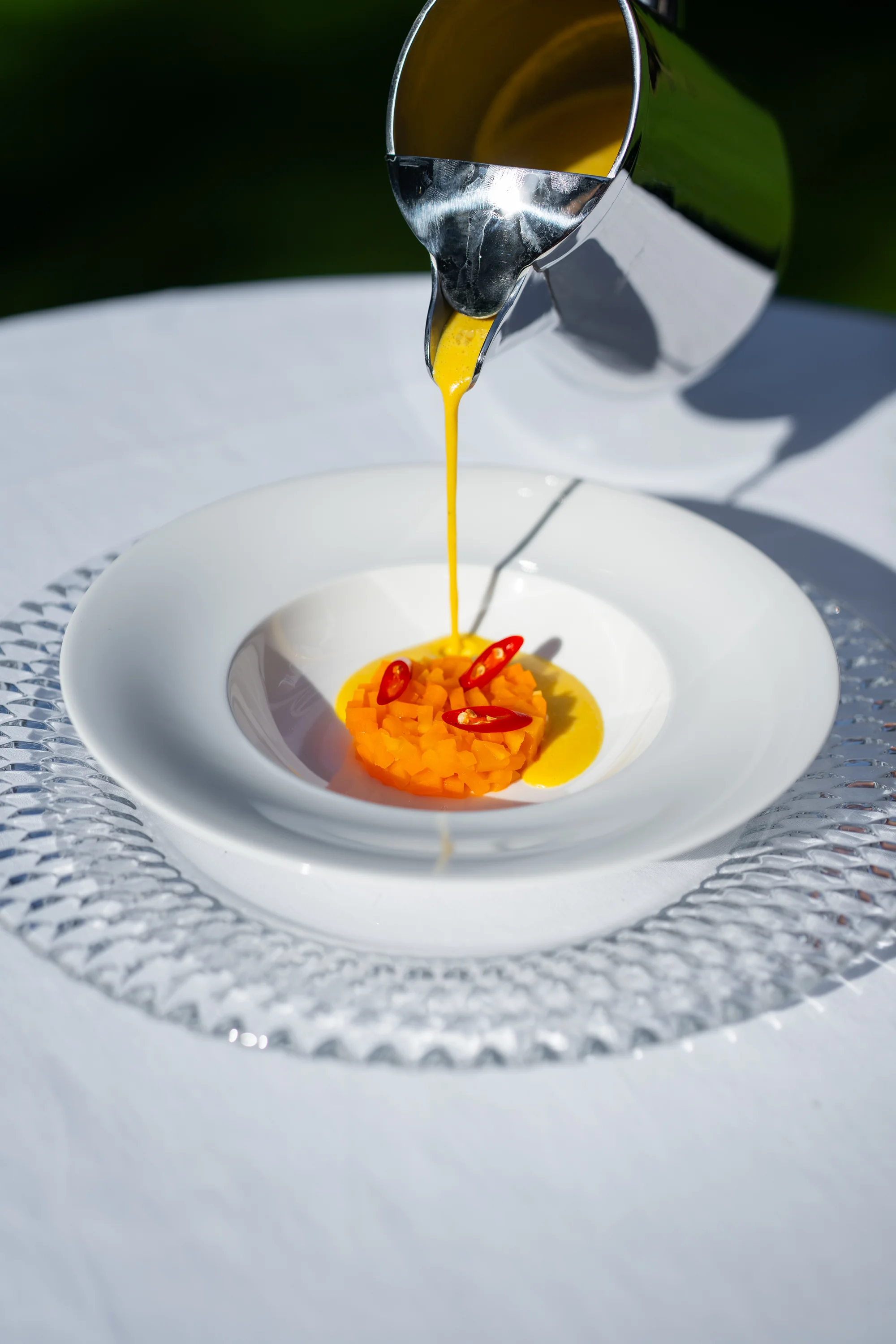 Pompoensoep wordt aan tafel over de pompoensalade geschonken