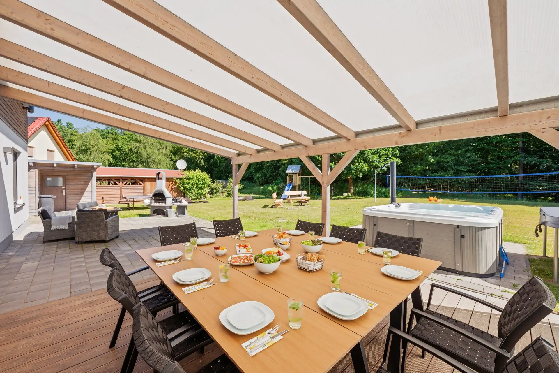 Überdachte Terrasse mit langem Esstisch und Hot Tub