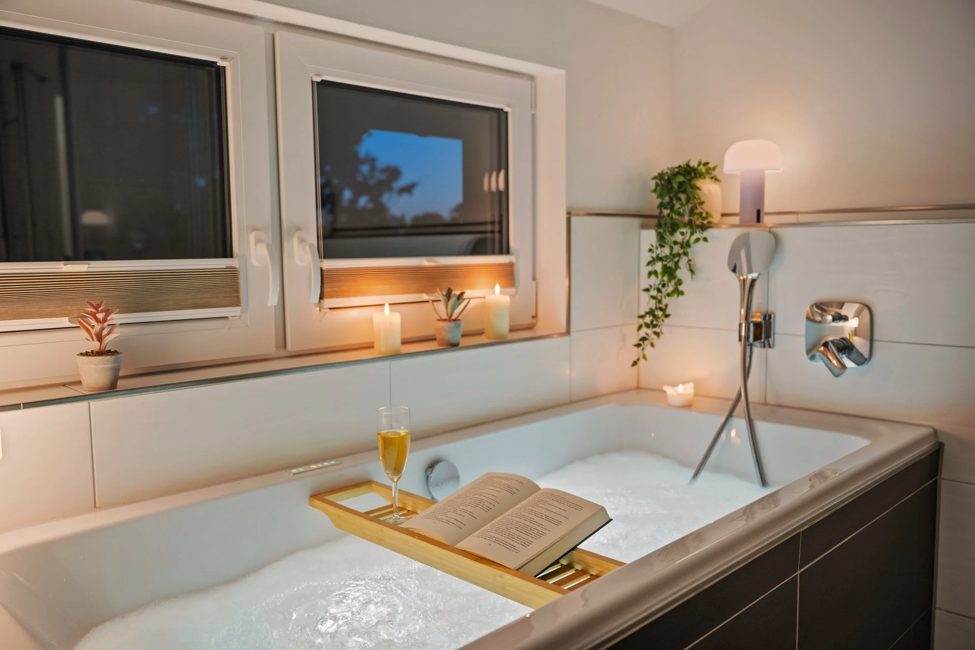 Badewanne mit Fensterblick und Kerzen am Rand