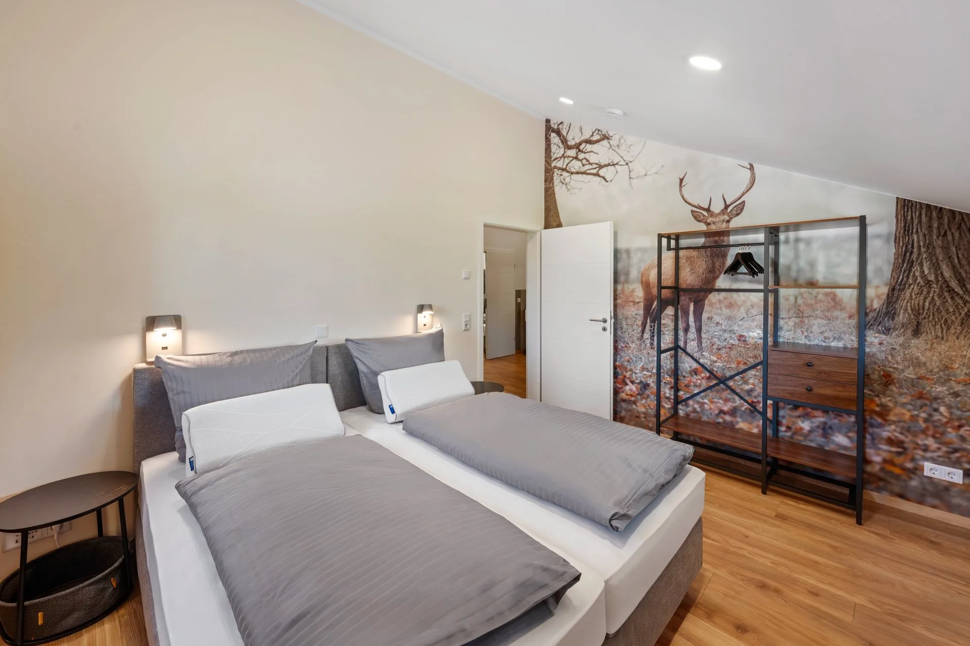Schlafzimmer mit zwei Betten und Hirschmotiv an der Wand