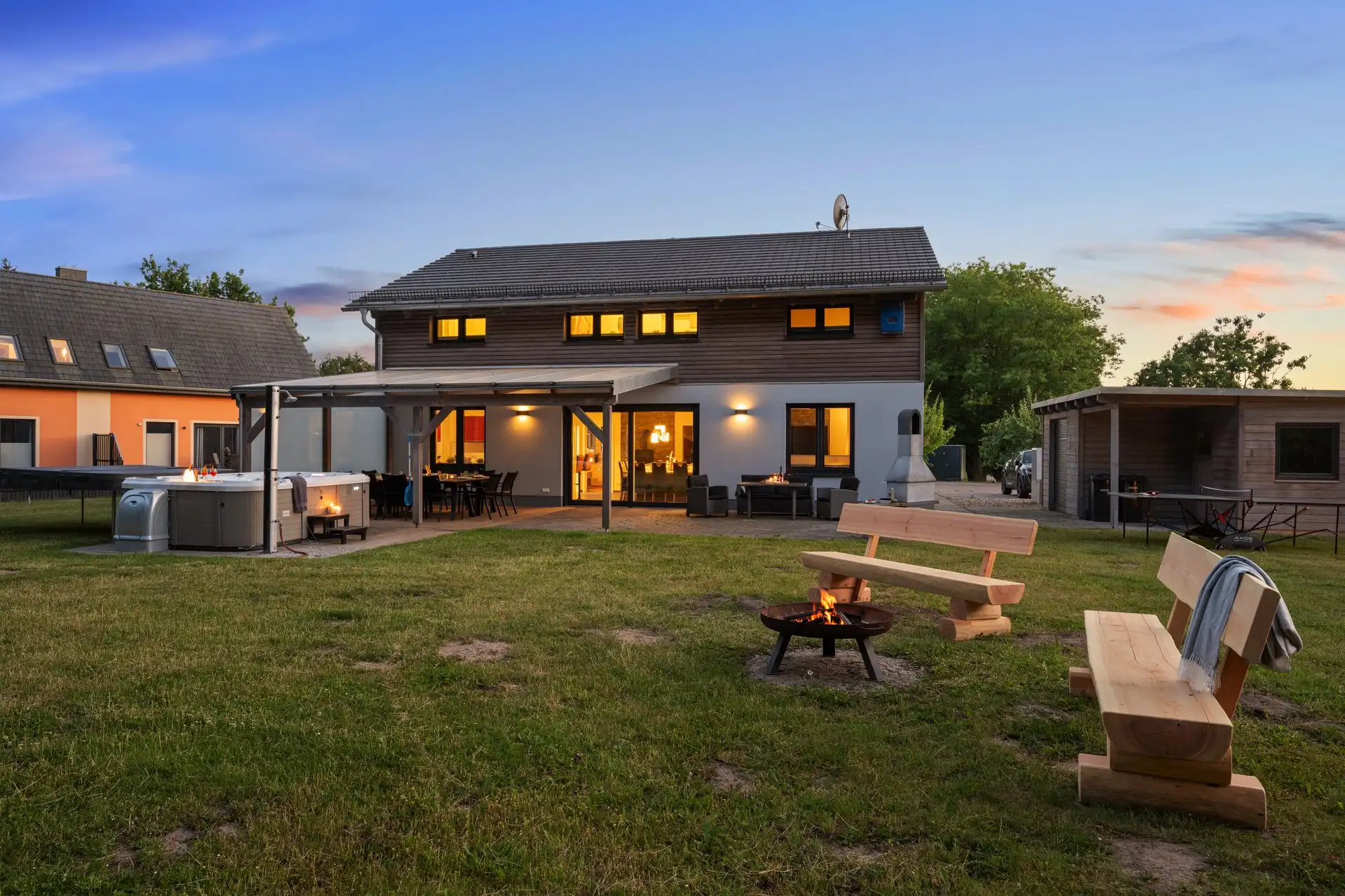 Ferienhaus am Plauer See mit beleuchteter Terrasse am Abend