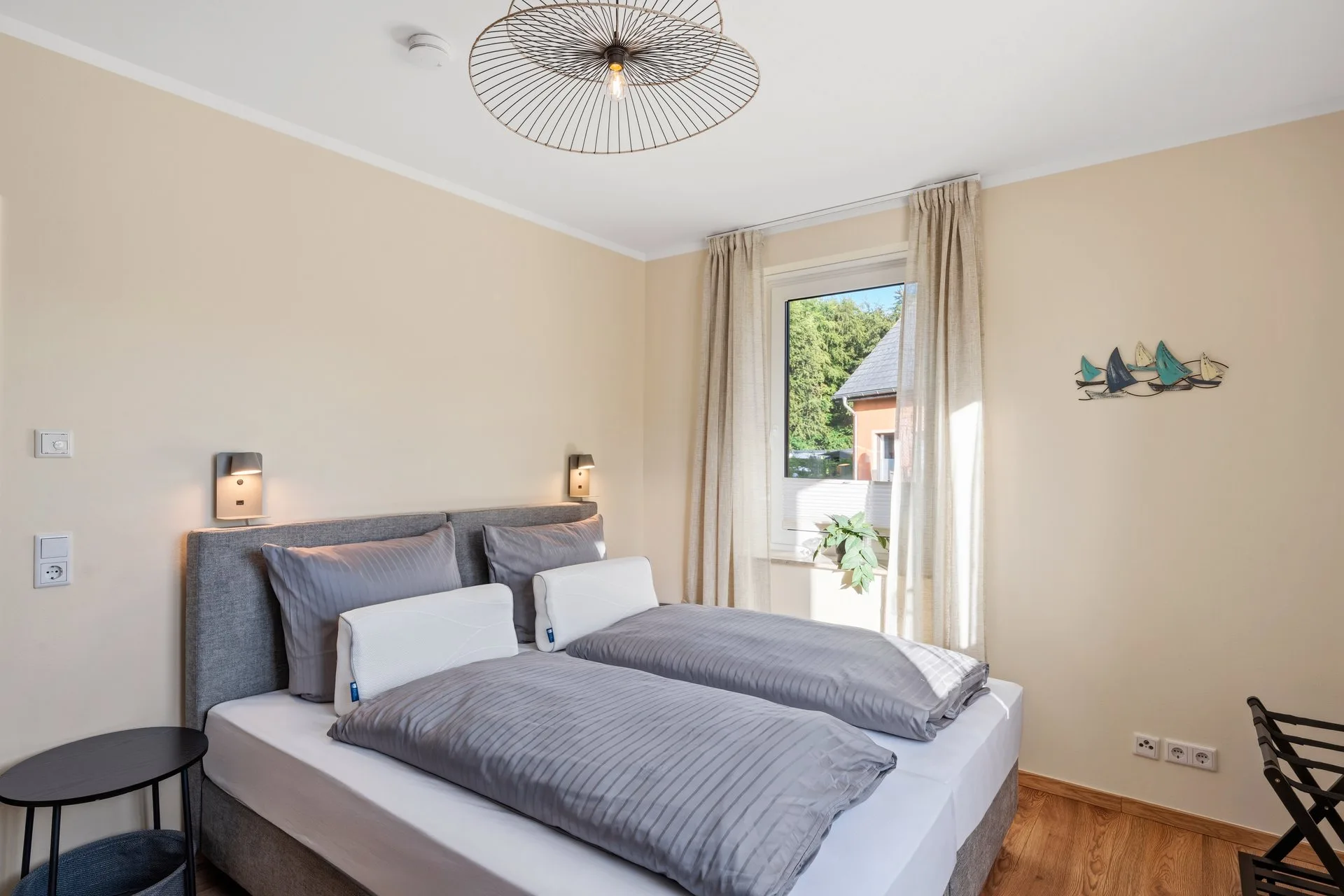 Bett am Fenster mit kleinen Wandbildern