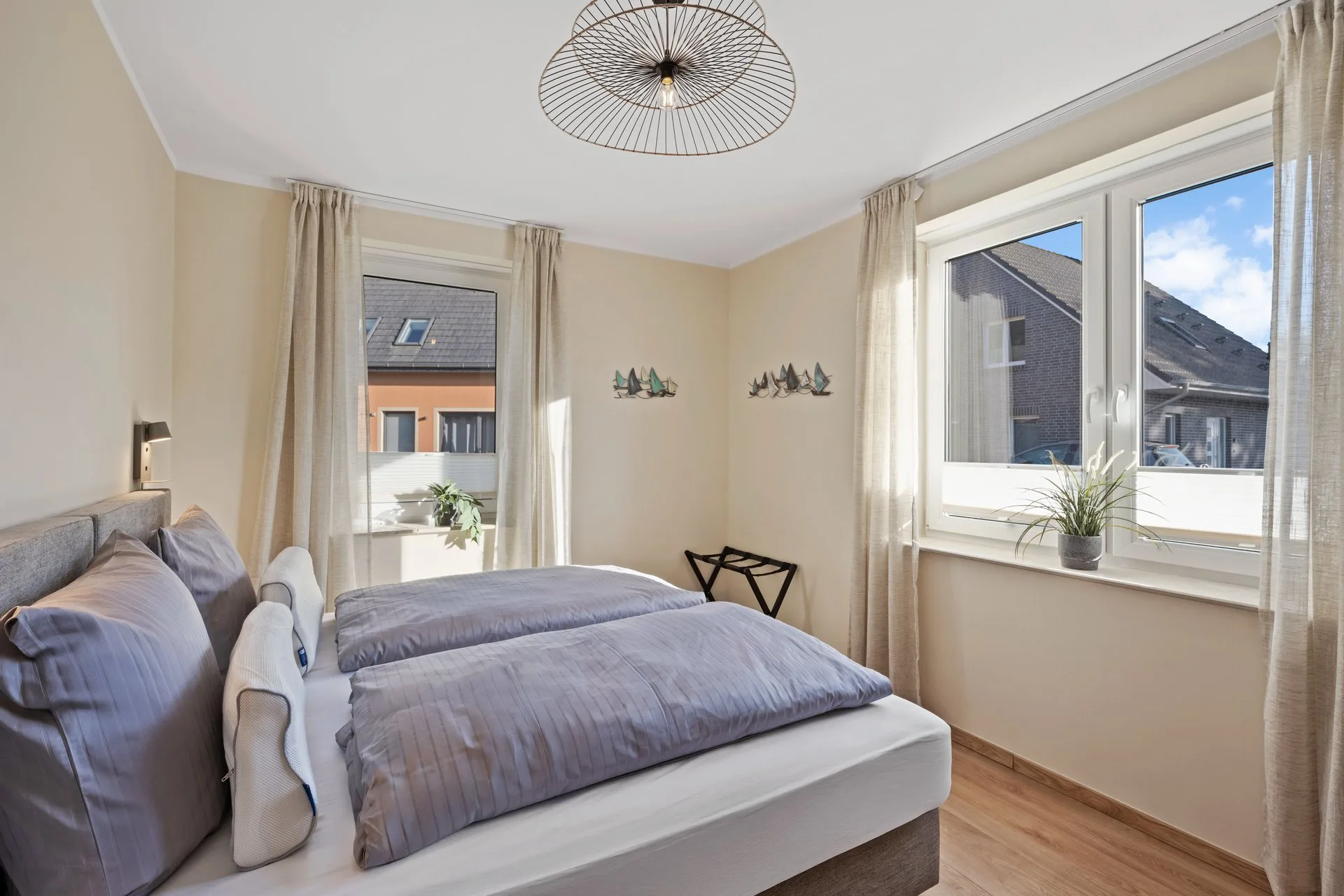 Schlafzimmer mit zwei Betten und Pflanzen auf der Fensterbank