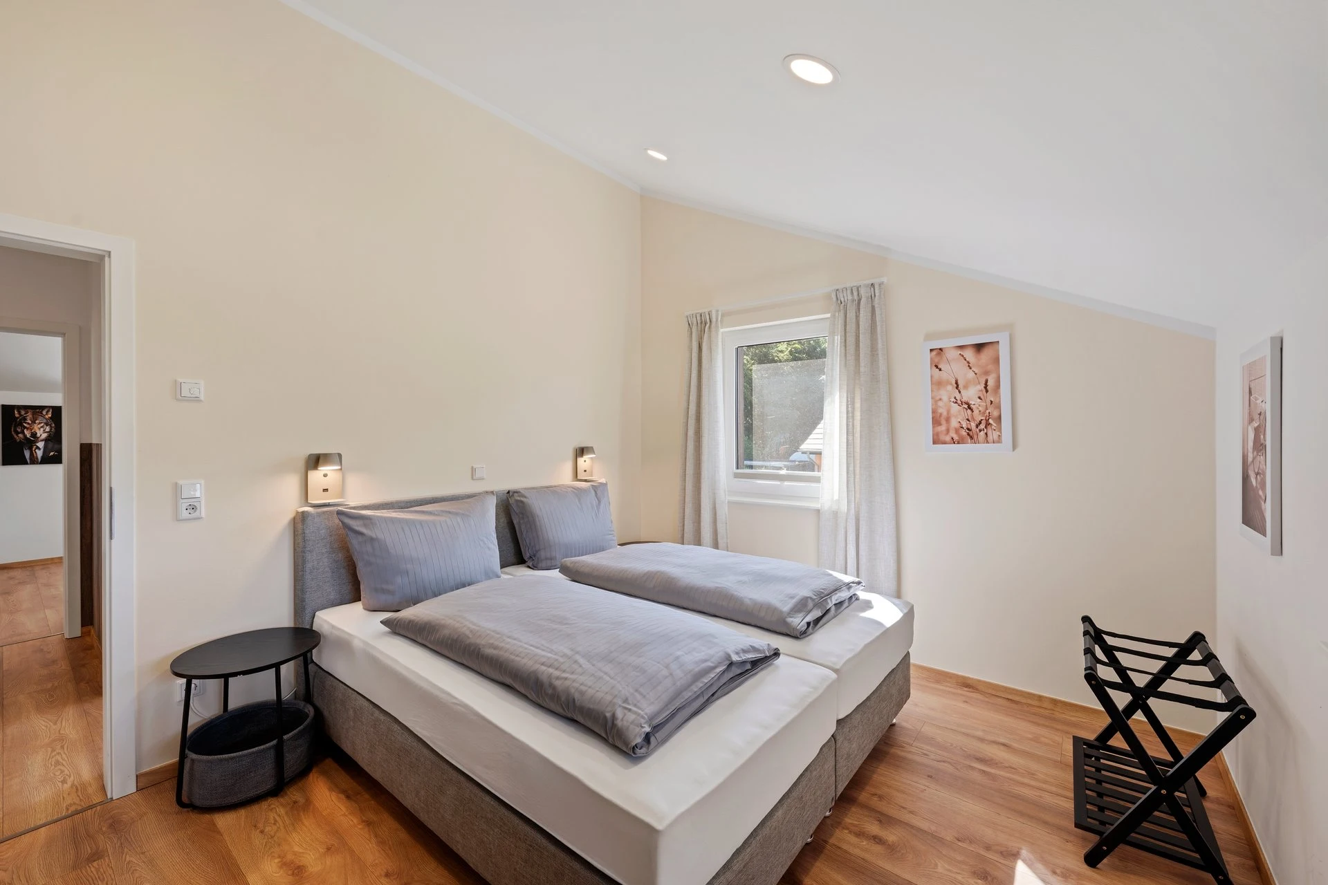 Schlafzimmer mit zwei Betten und Blumenbild an der Wand