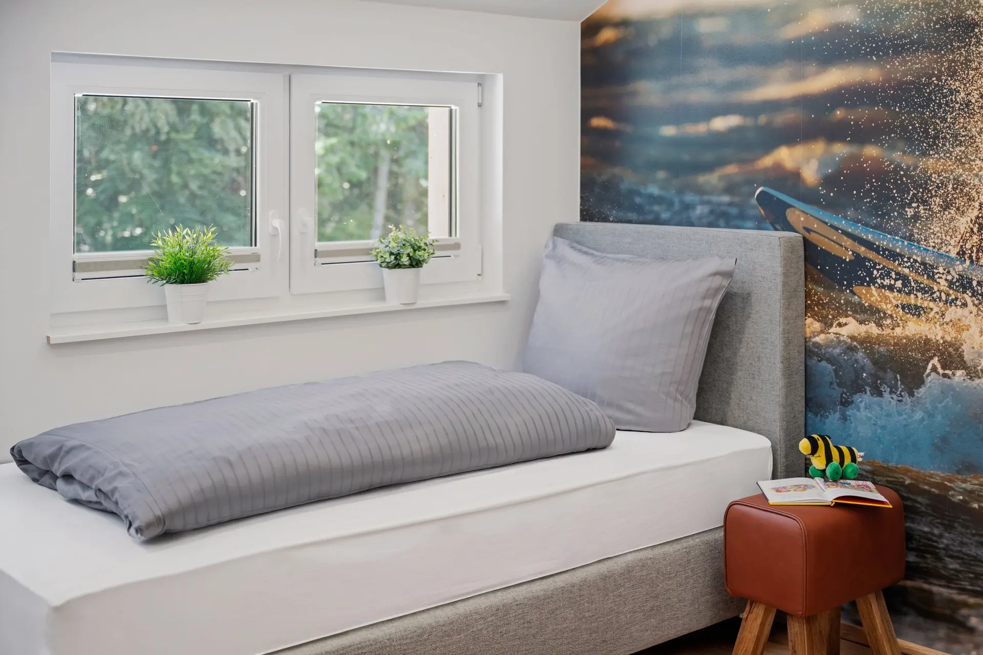 Fensterbank mit Sitzkissen und buntem Wandbild