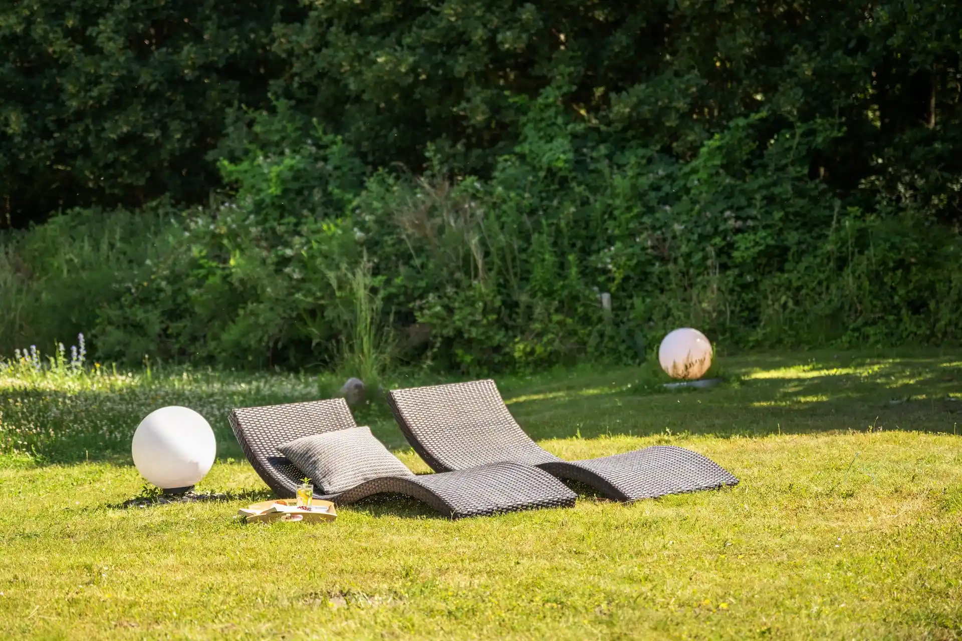 Liegestühle im Garten am Rasenrand