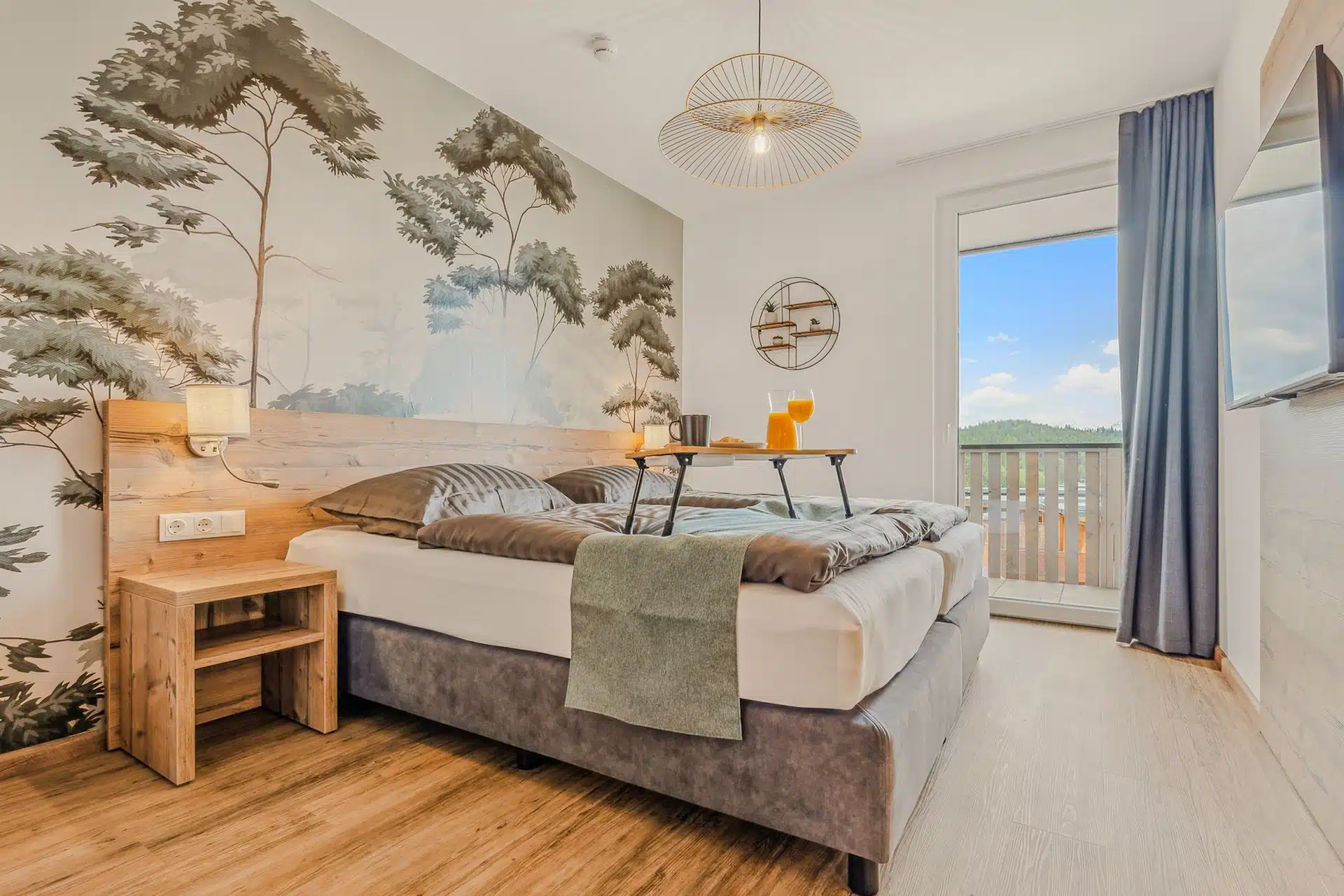 Schlafzimmer mit Kiefernmotiv-Wandbild und Balkonzugang
