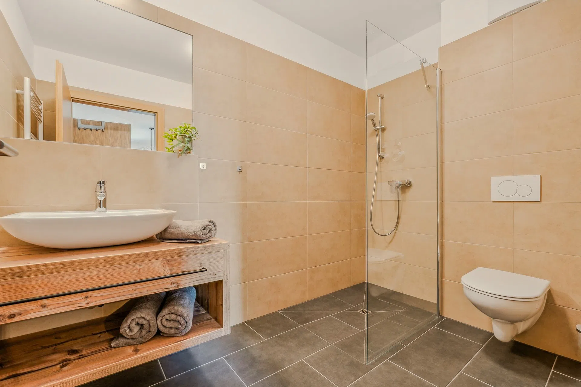 Badezimmer mit Holzwaschtisch und begehbarer Dusche