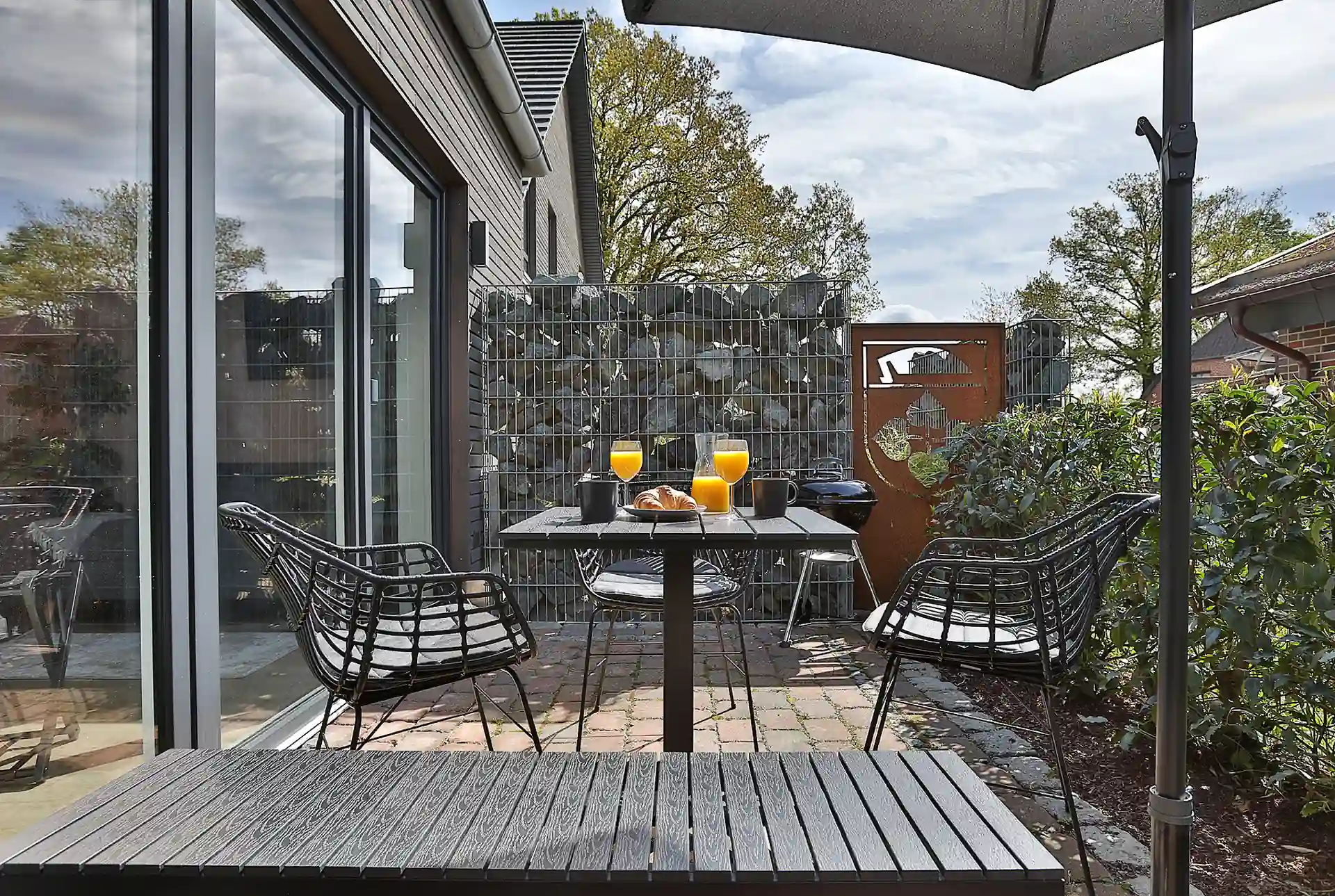 Terrasse mit Sitzgruppe und Sichtschutz aus Gabionen