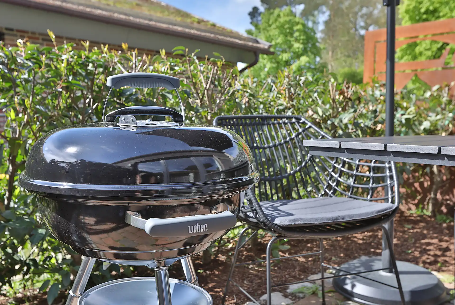Kugelgrill auf der Terrasse mit Sitzgelegenheit