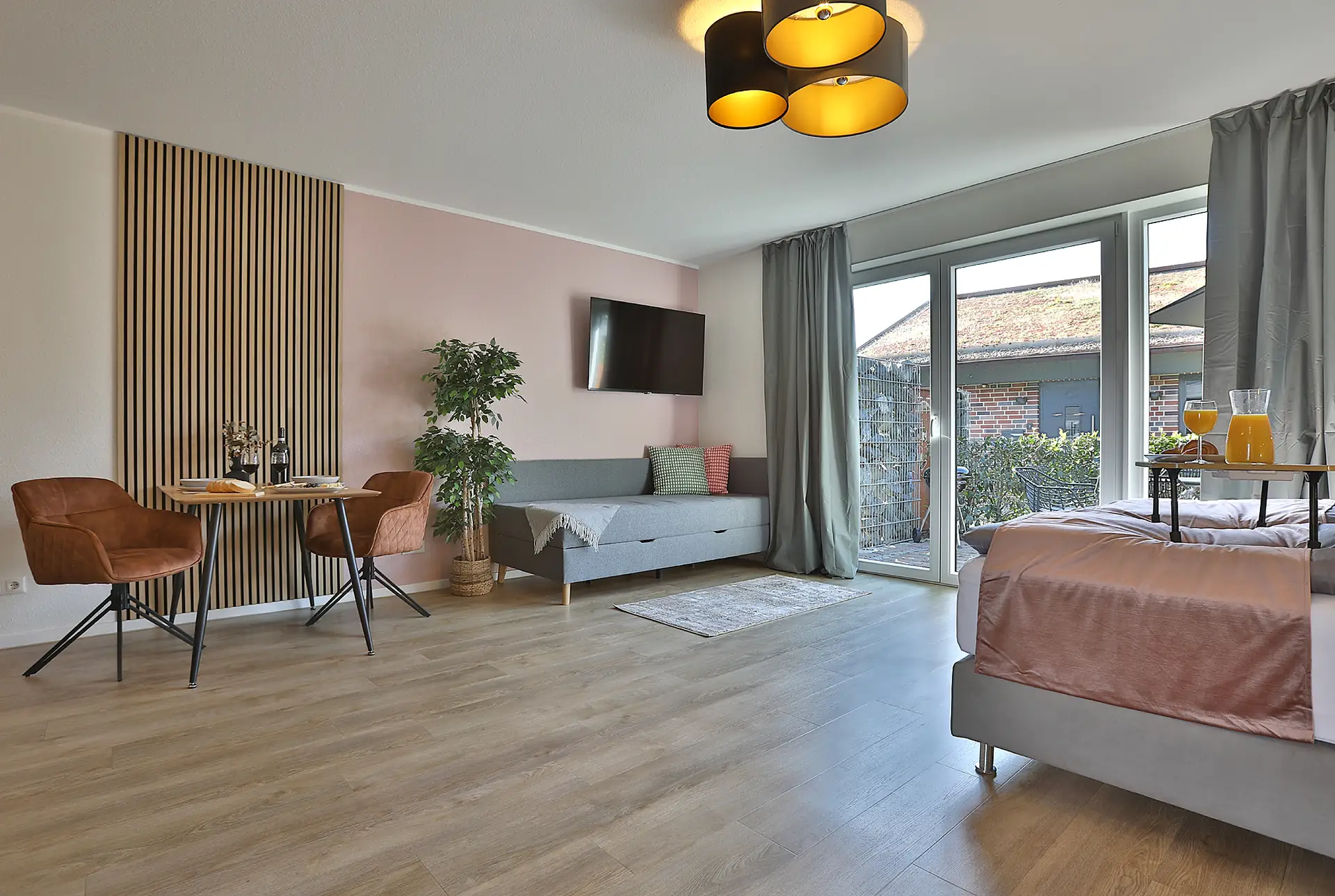 Offener Wohn- und Schlafraum mit Sofa und Esstisch