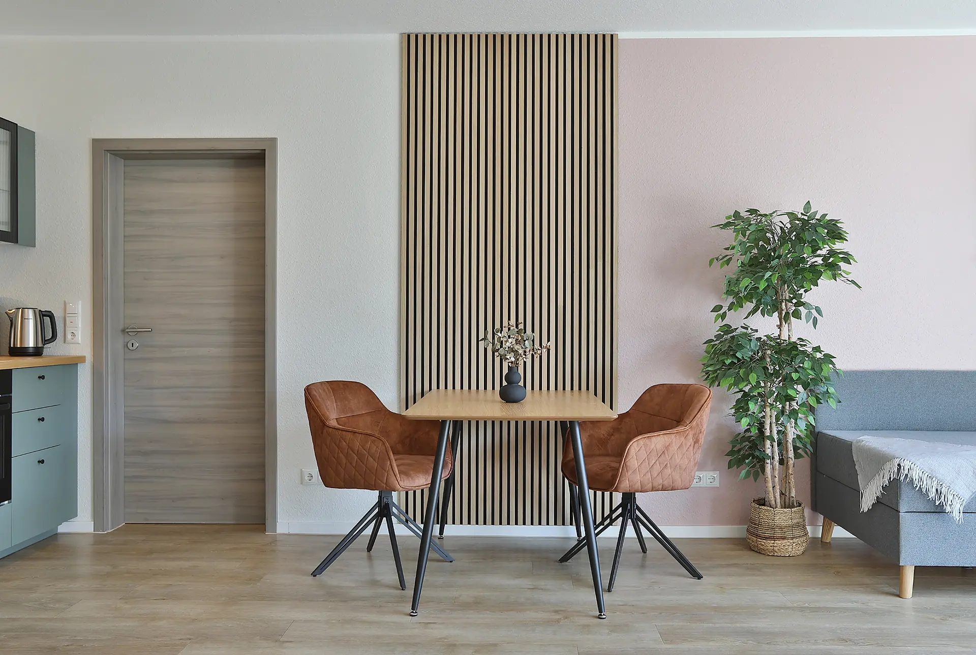 Essecke mit Holzlamellen-Wand und zwei Sesseln