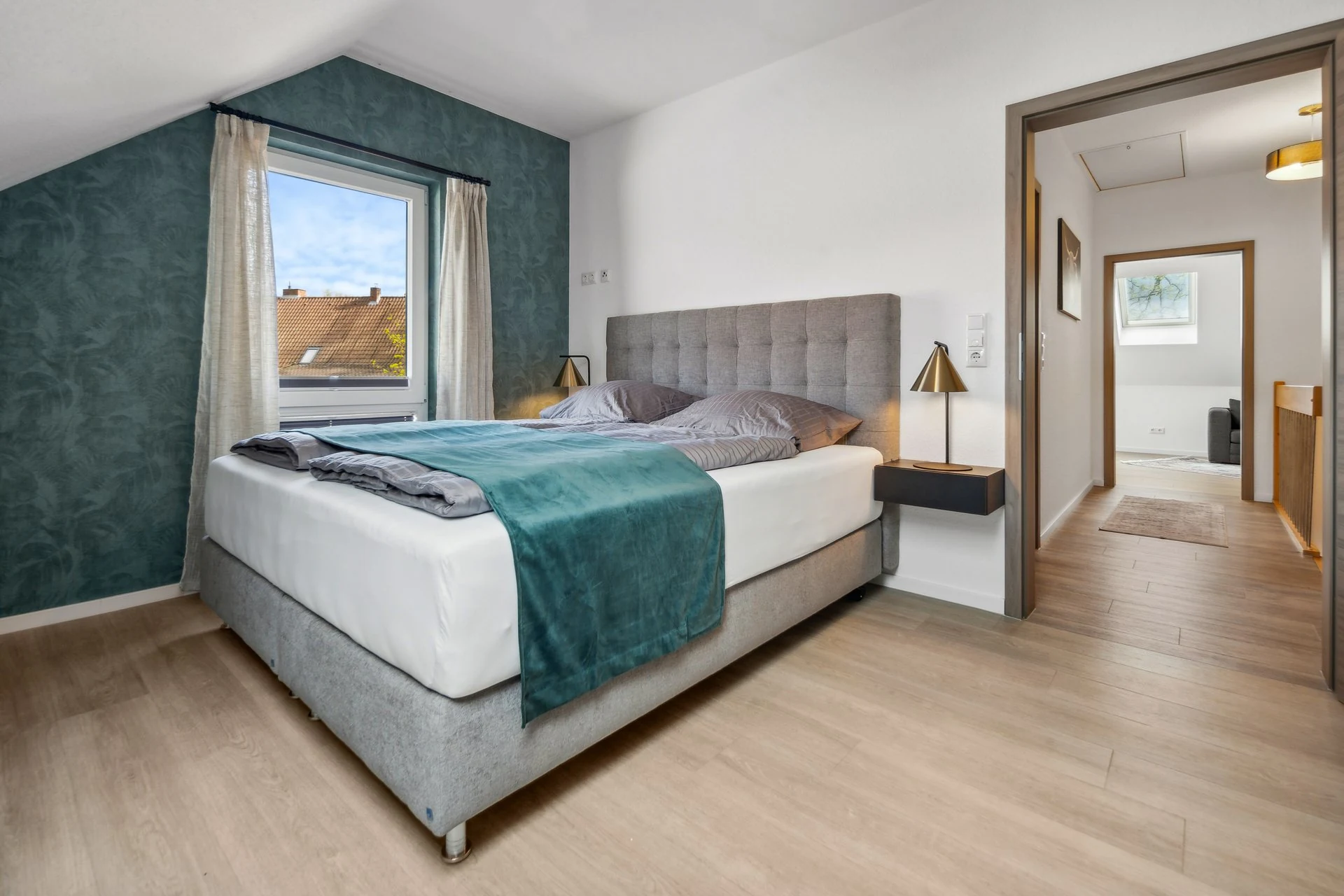 Dachschlafzimmer mit Fensterblick und grüner Wandnische
