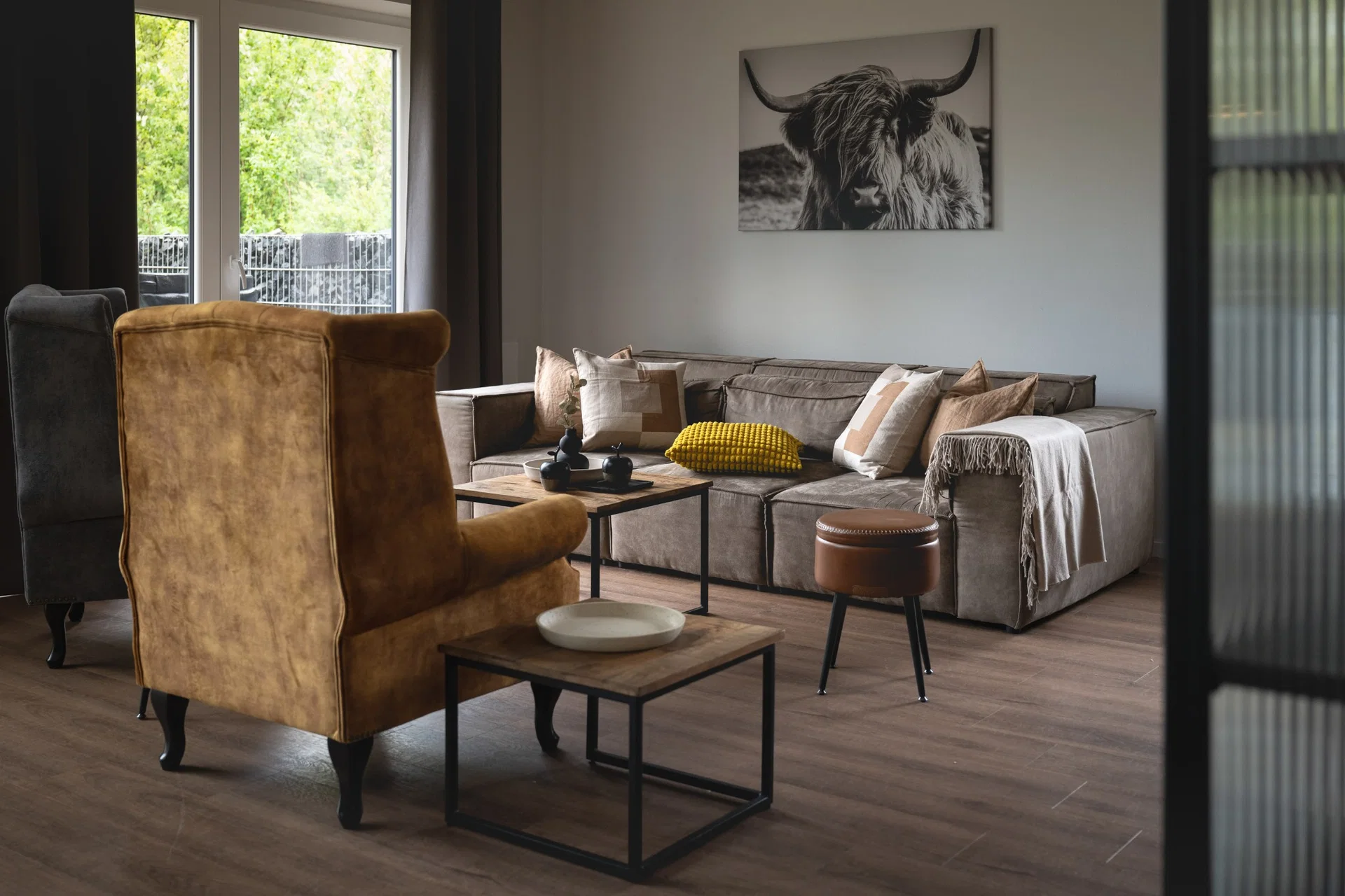 Wohnzimmer mit Sofa und Kuh-Wandbild
