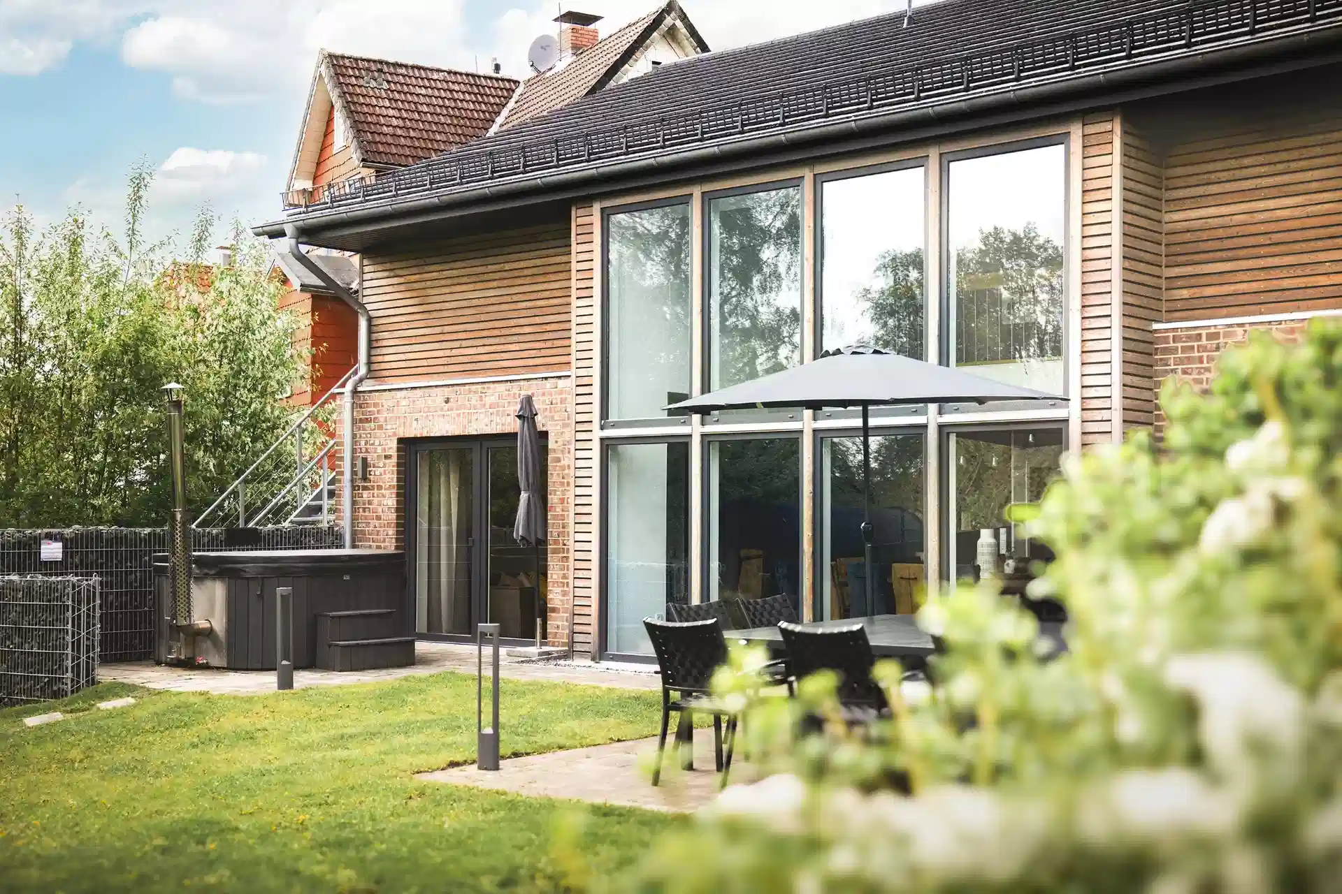 Terrasse mit Glasanbau und Blick in den Garten