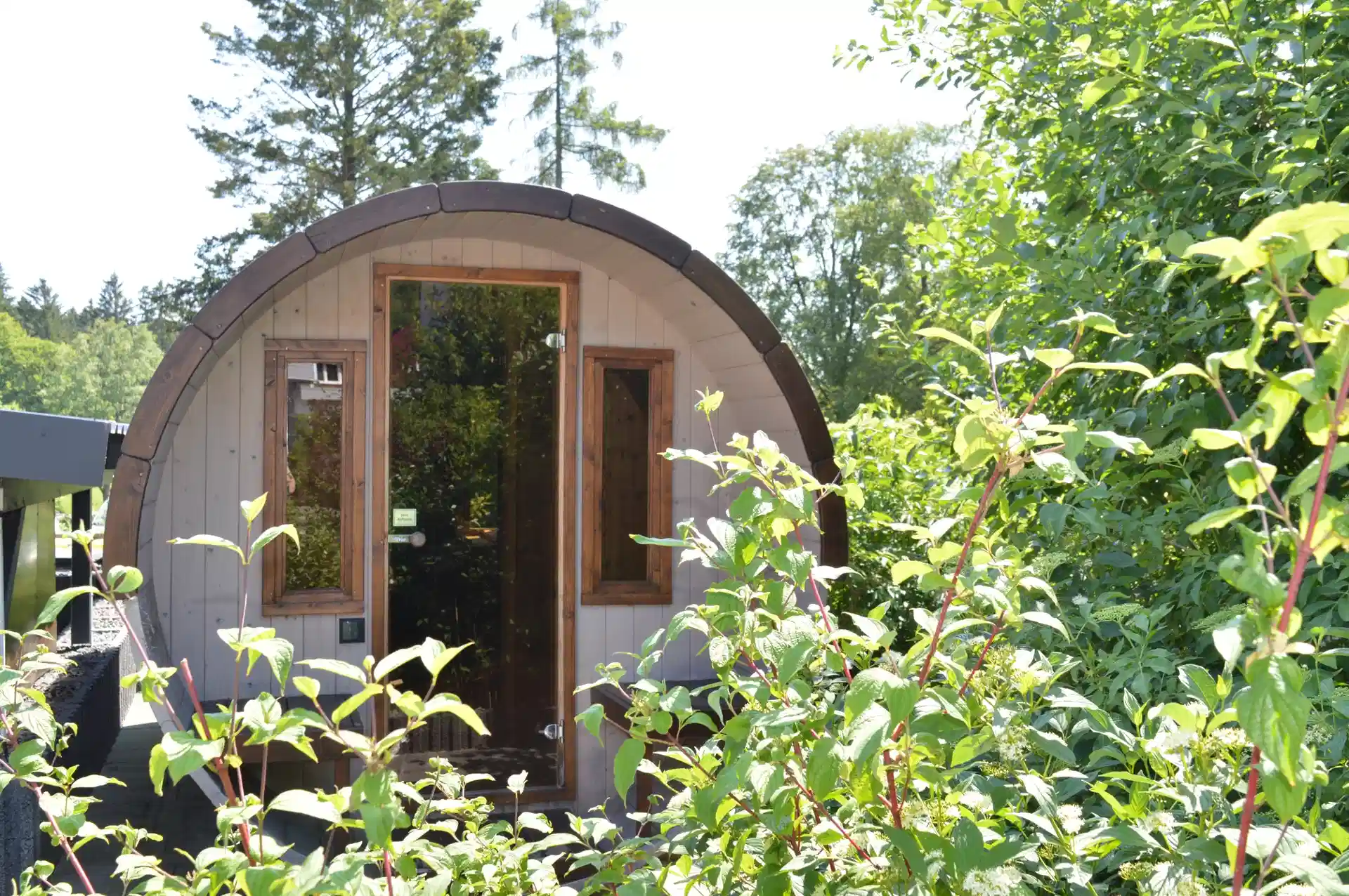 Fasssauna im Garten mit Glastür
