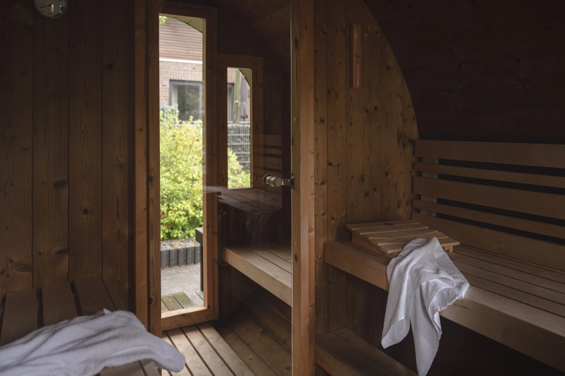 Sauna mit Holzbänken und Blick in den Garten