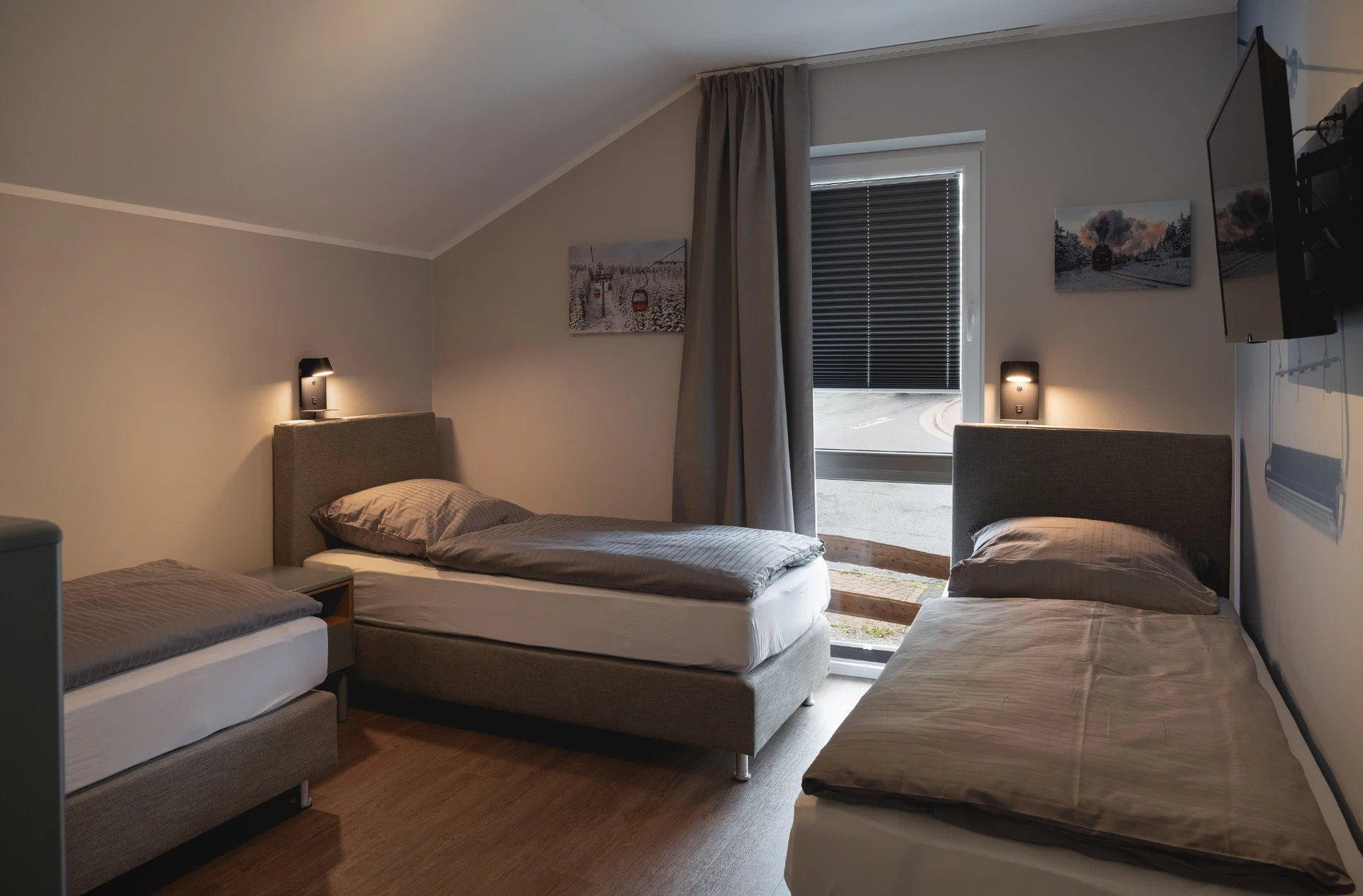 Schlafzimmer mit drei Betten und Balkonzugang