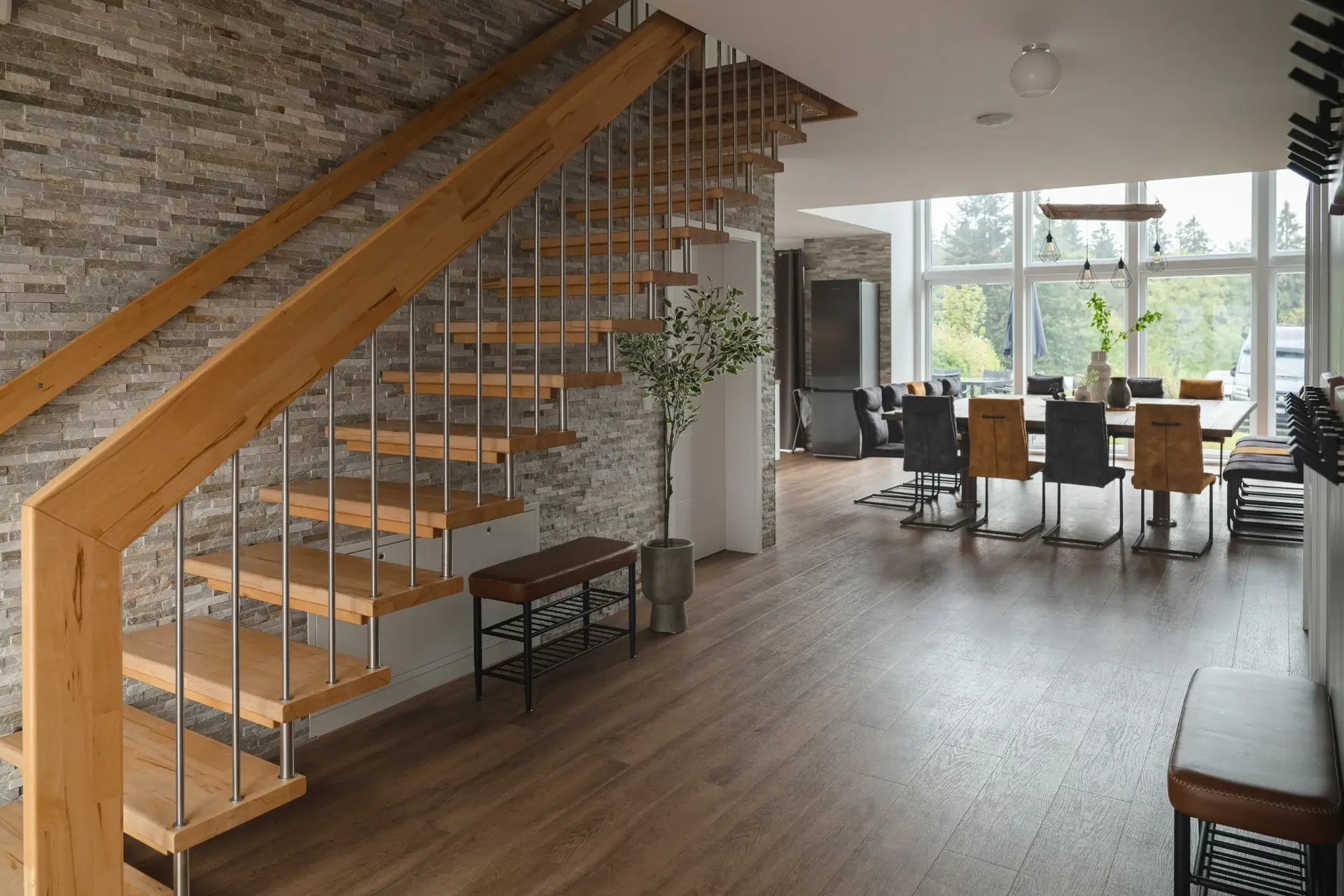 Holztreppe vor Natursteinwand mit Sitzbank
