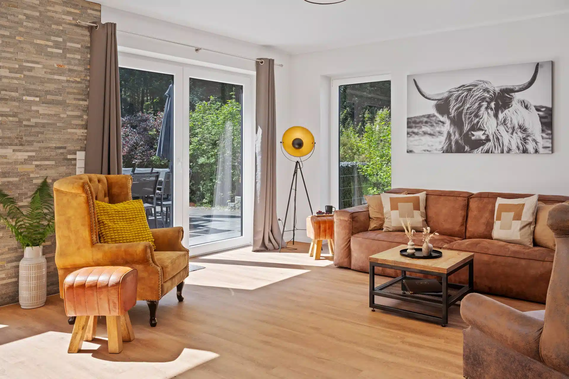 Wohnzimmer mit Sessel und Kuh-Wandbild