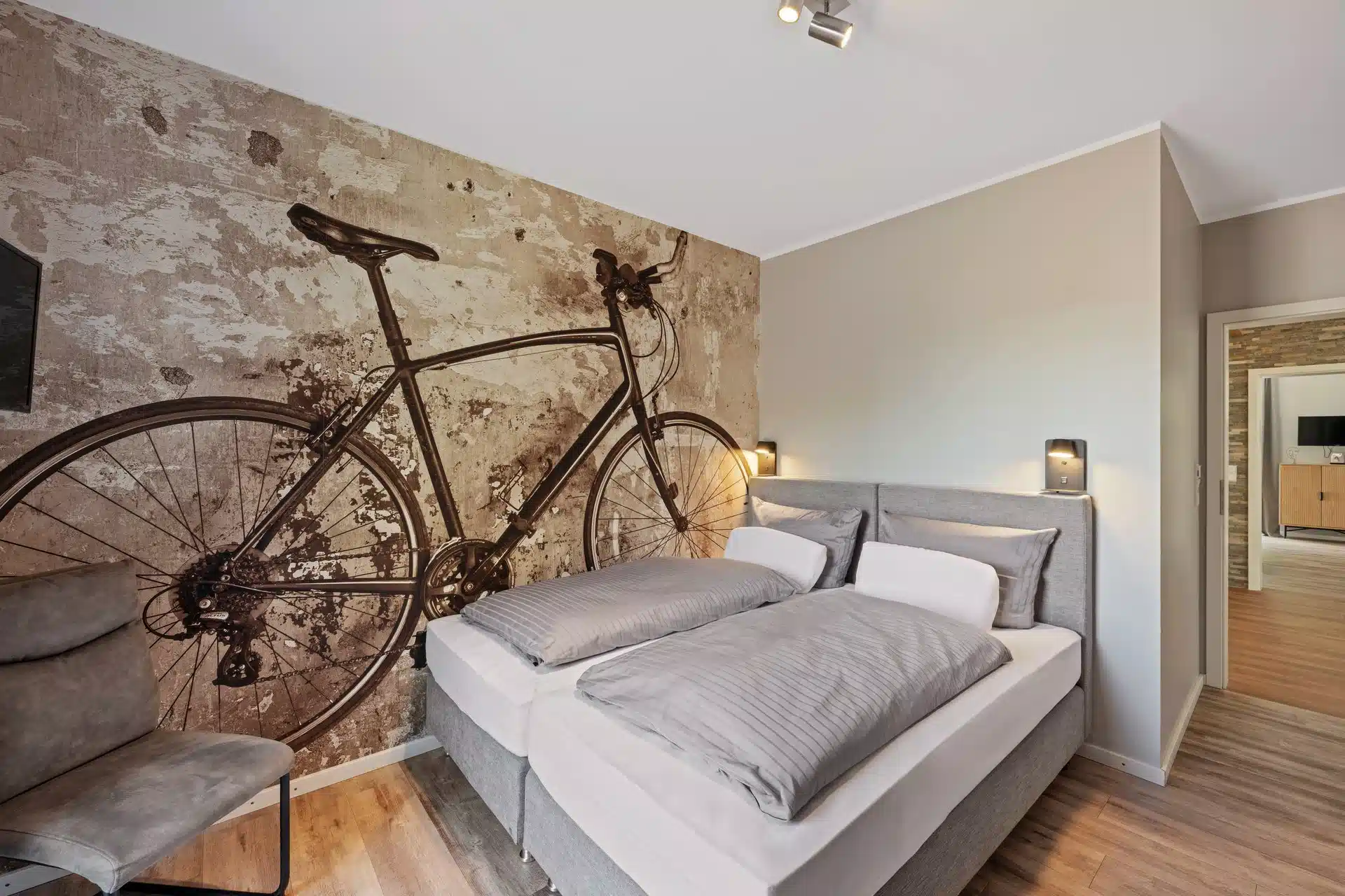 Schlafzimmer mit Fahrrad-Wandbild auf Backstein-Optik