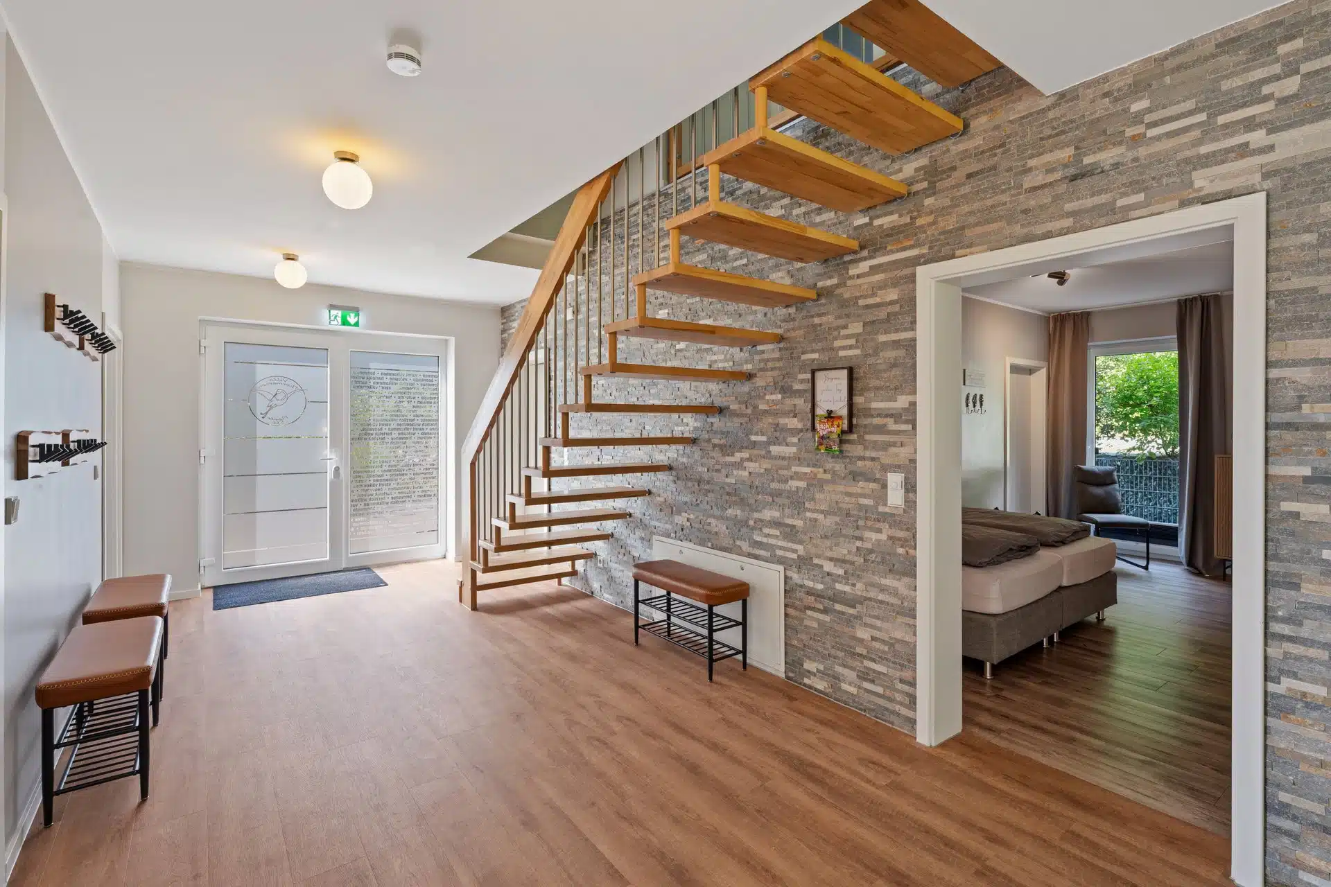 Eingangsbereich mit Treppe vor Natursteinwand