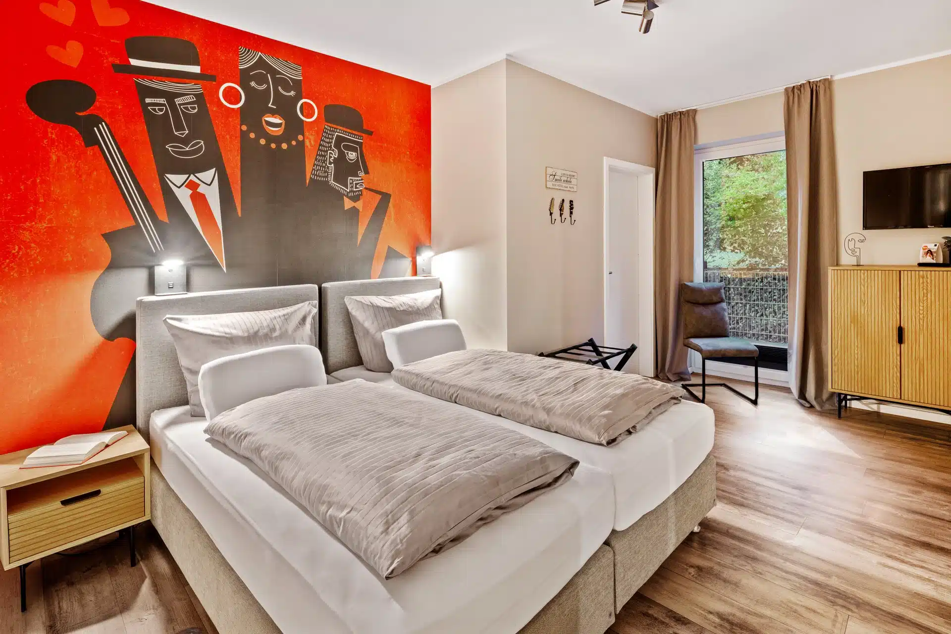 Schlafzimmer mit buntem Musik-Wandbild und Balkon
