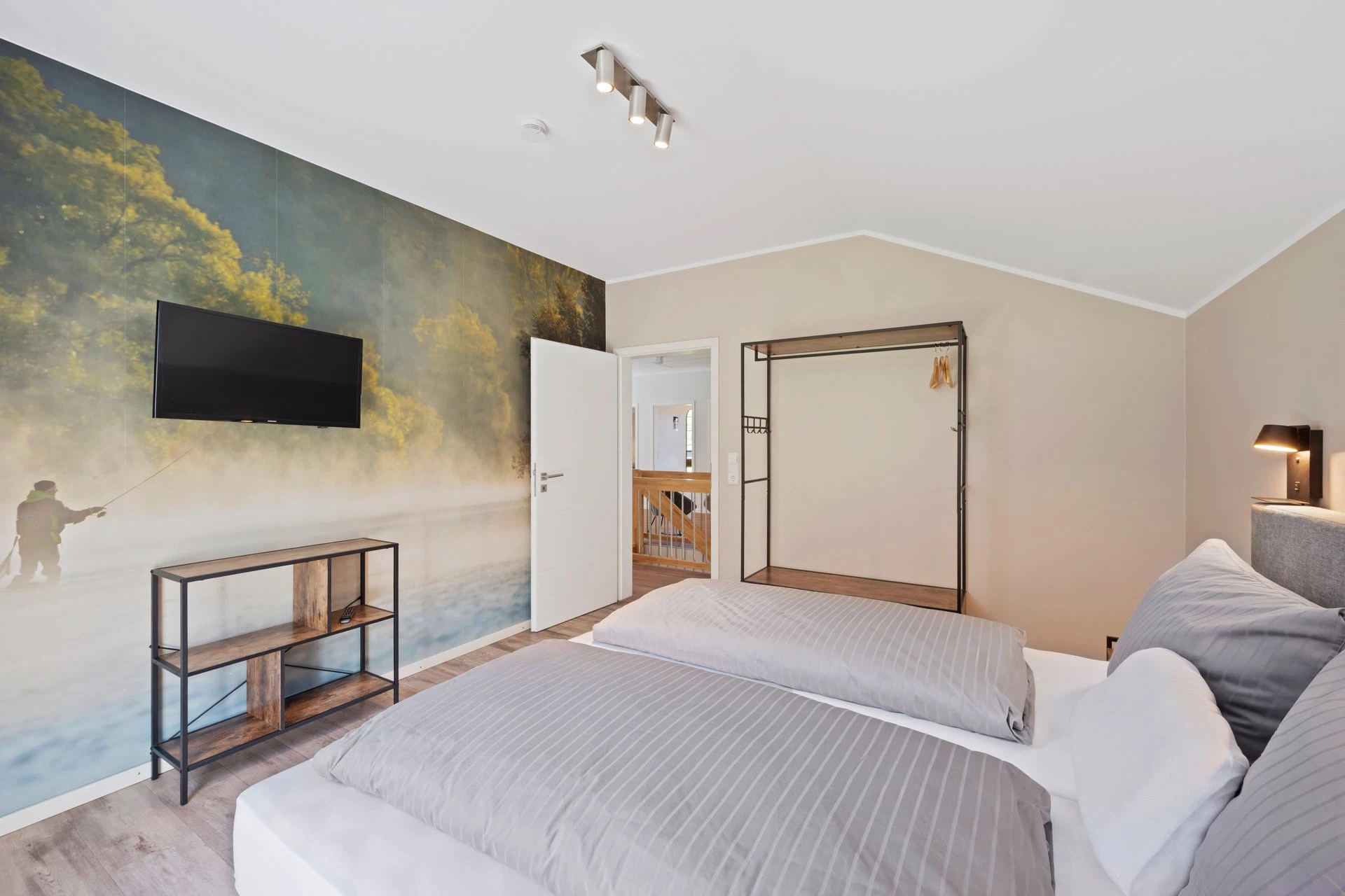 Schlafzimmer mit Angler-Wandbild und Fernseher