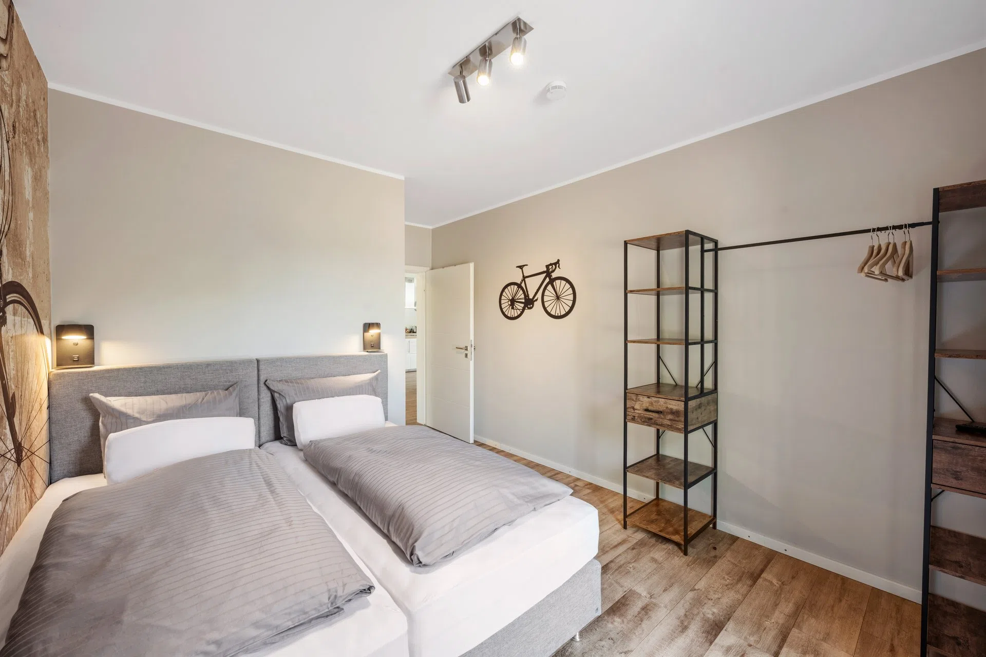 Schlafzimmer mit Fahrrad-Deko und offenem Kleiderschrank