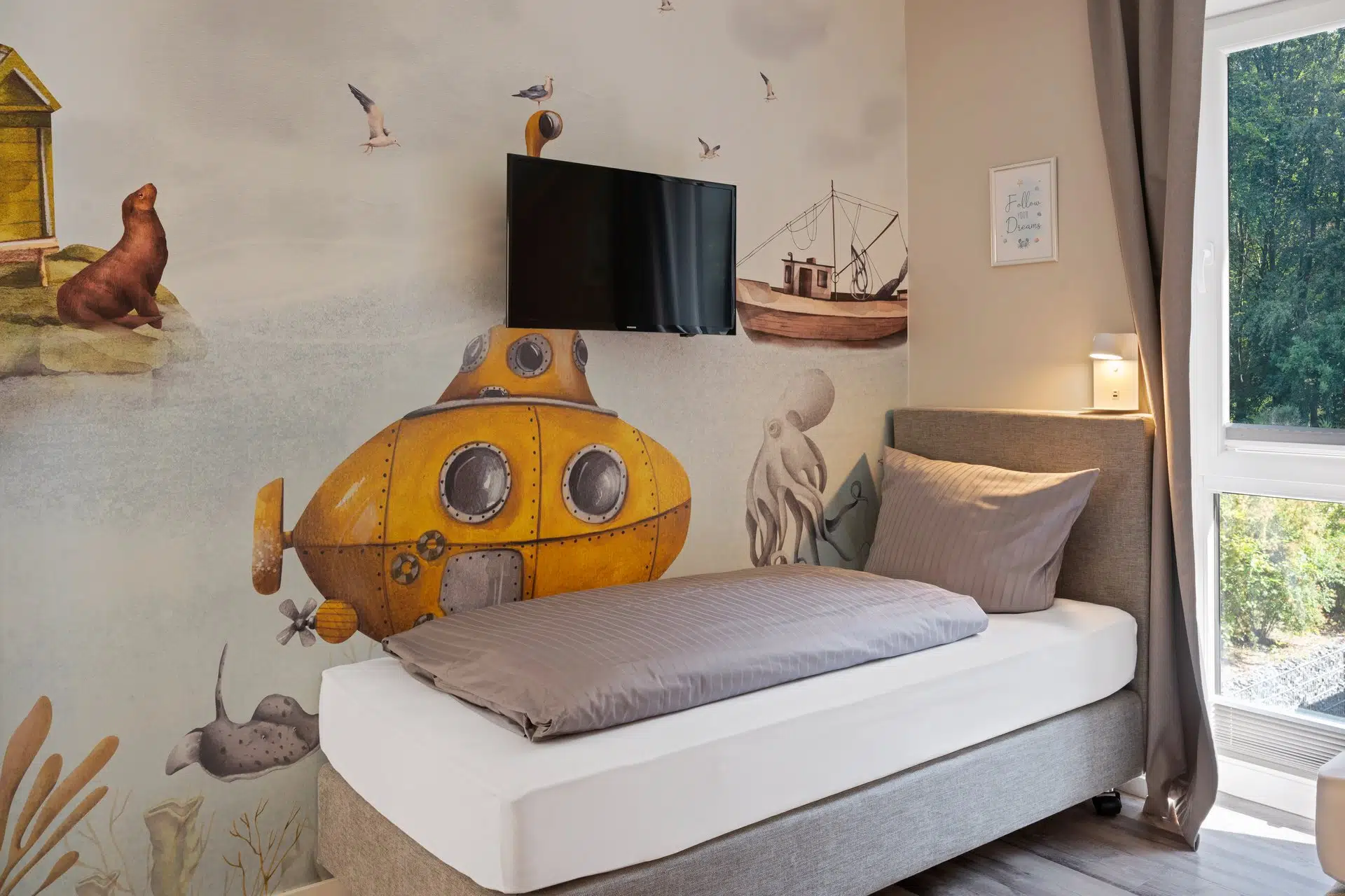 Einzelbett vor U-Boot-Wandbild mit Meerestieren